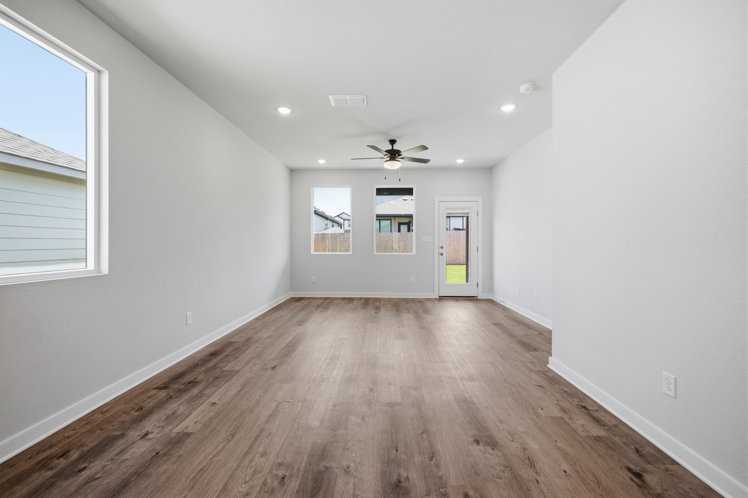 A room with a wood floor and a ceiling fan.