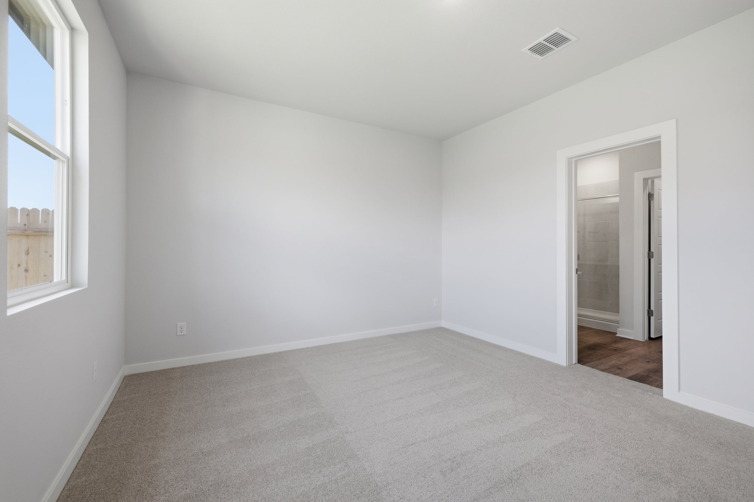 A room with a carpet and a door.