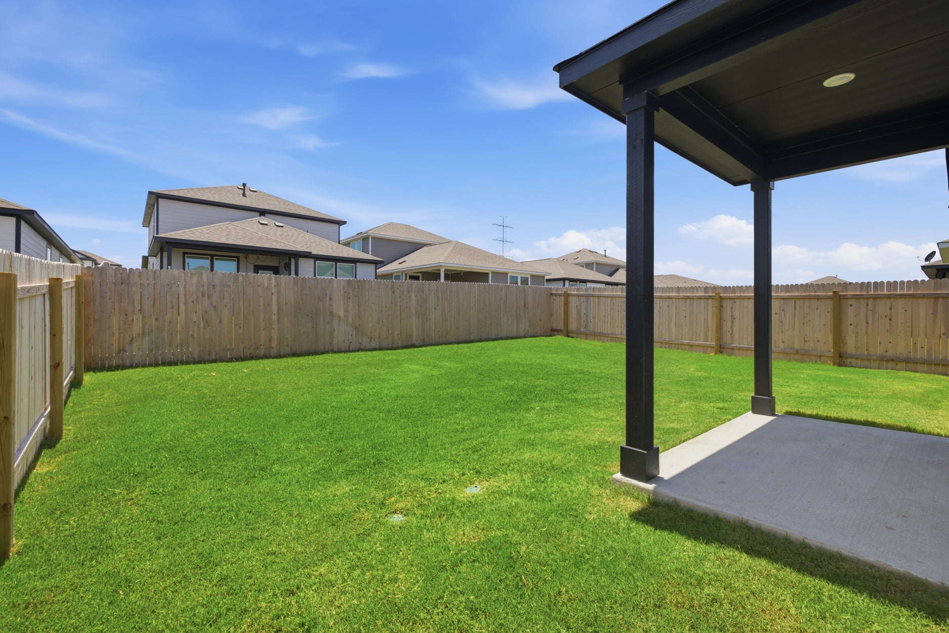 A backyard with a fence and a wood fence.