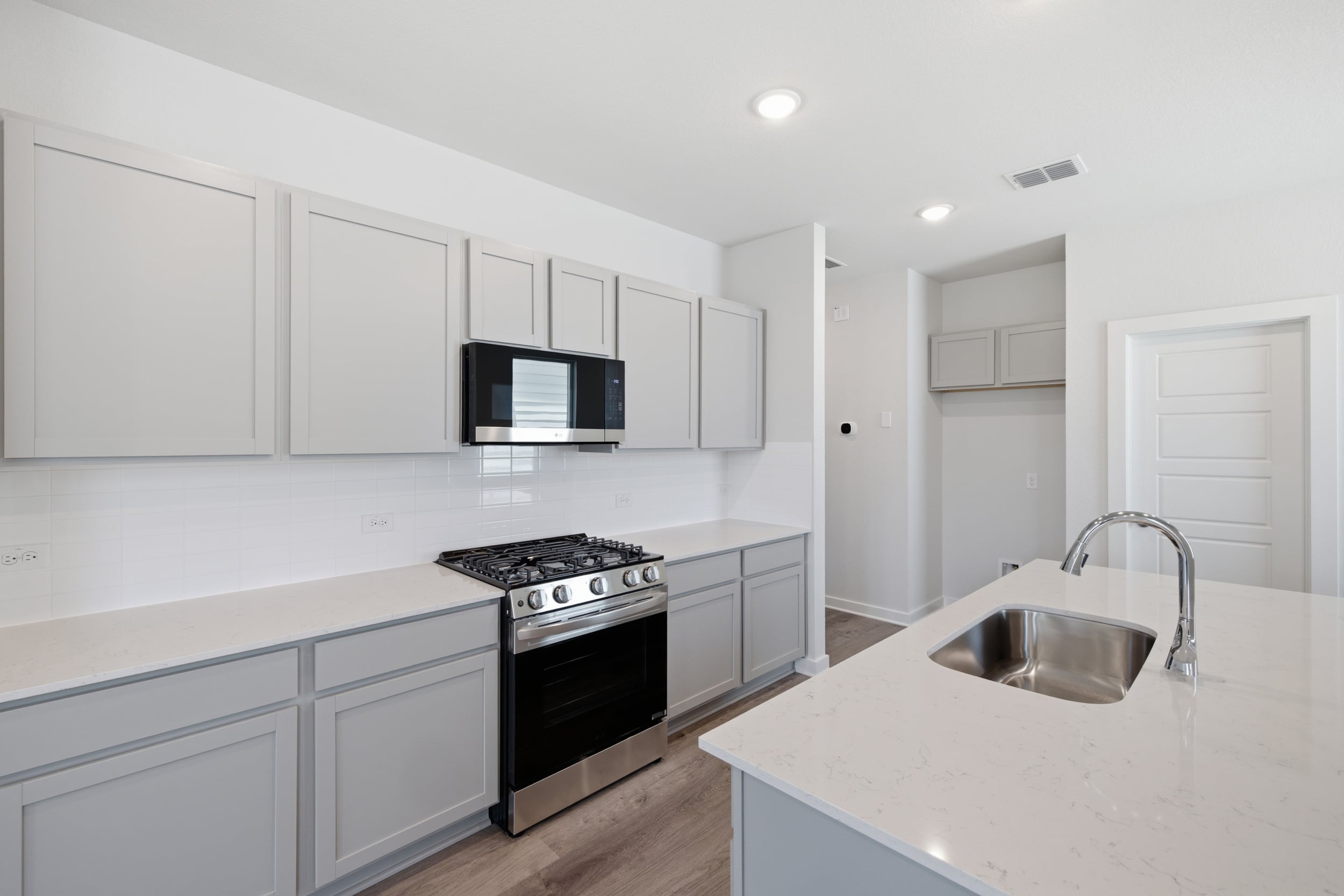 A kitchen with white cabinets.