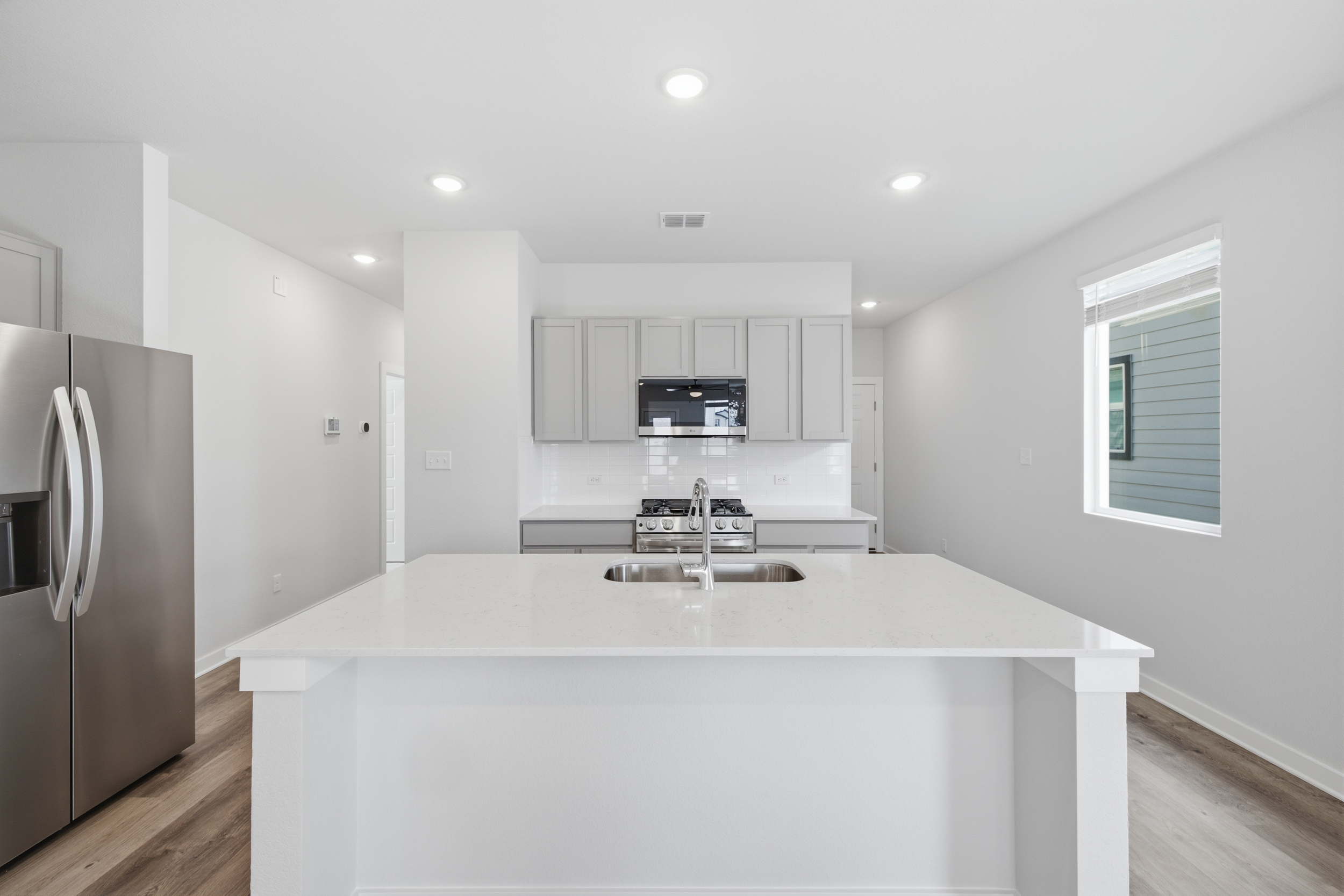 A kitchen with white cabinets.