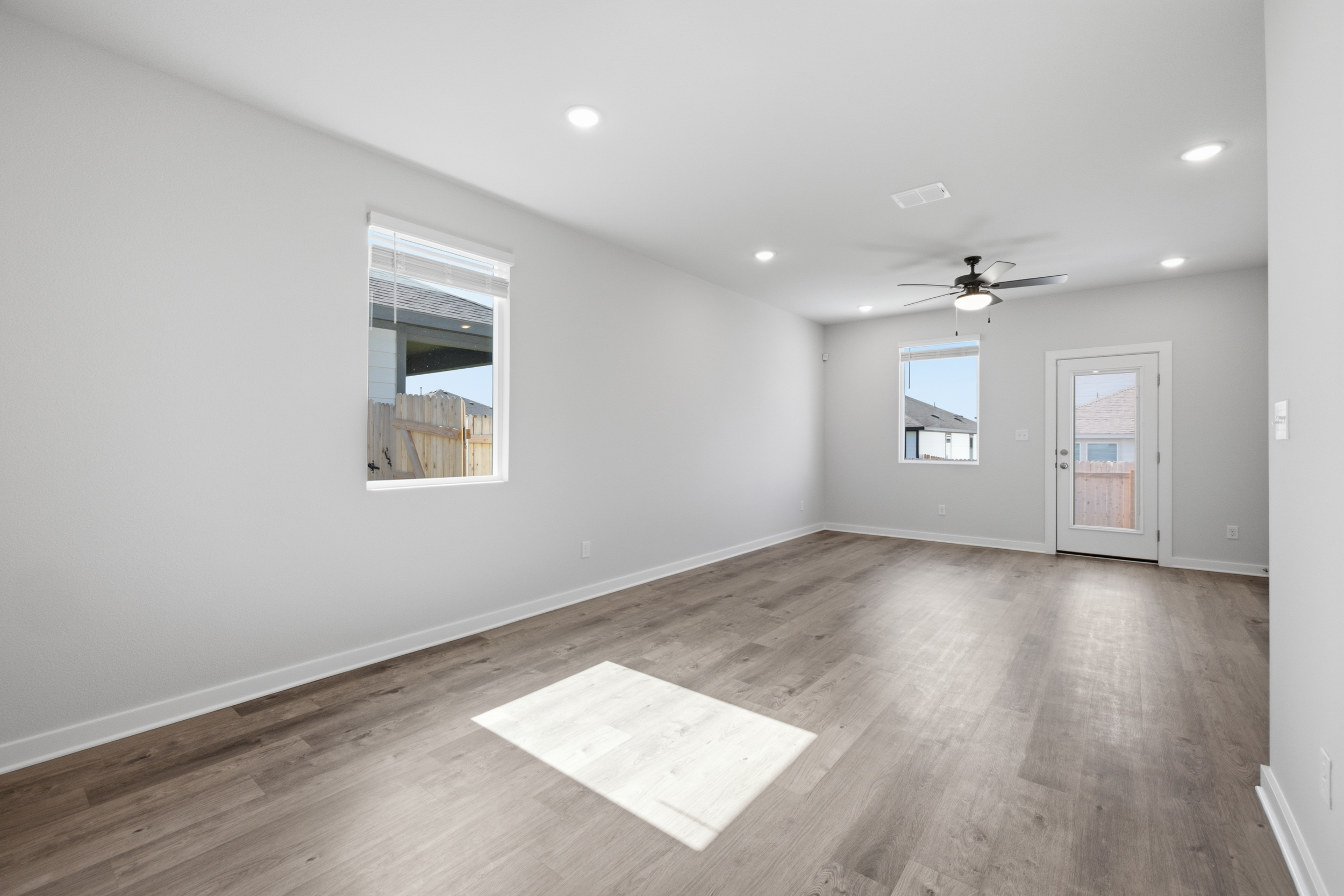 A room with a wood floor and a wood floor with a window.