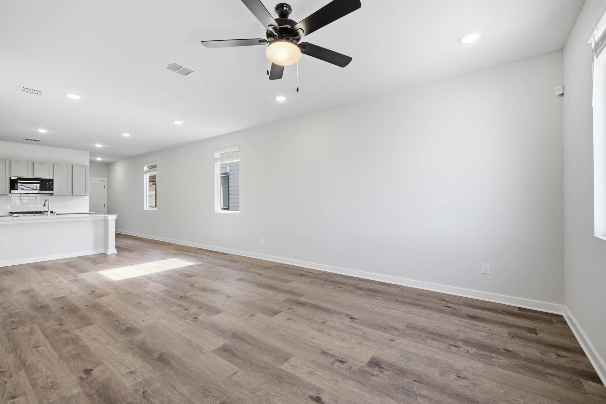 A room with a wood floor and a ceiling fan.