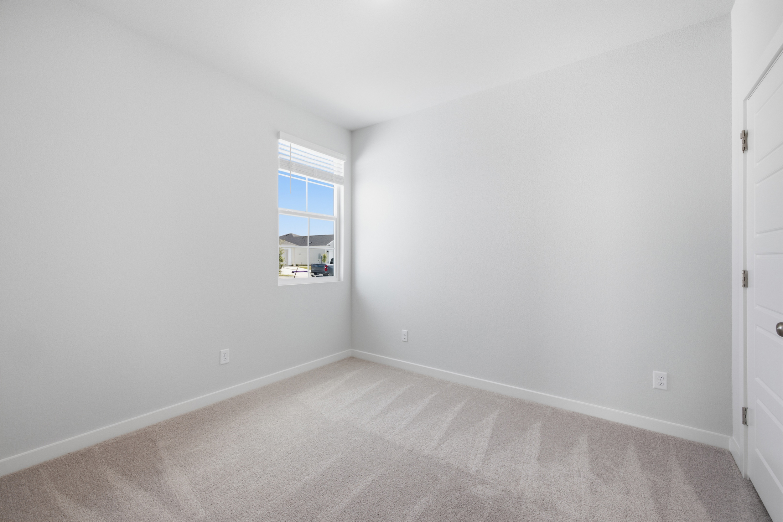 A room with a window and a carpet.