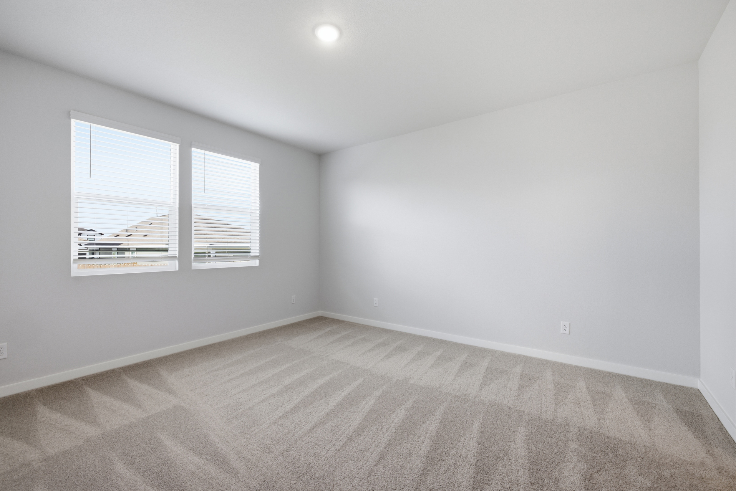 A room with a window and a carpet.