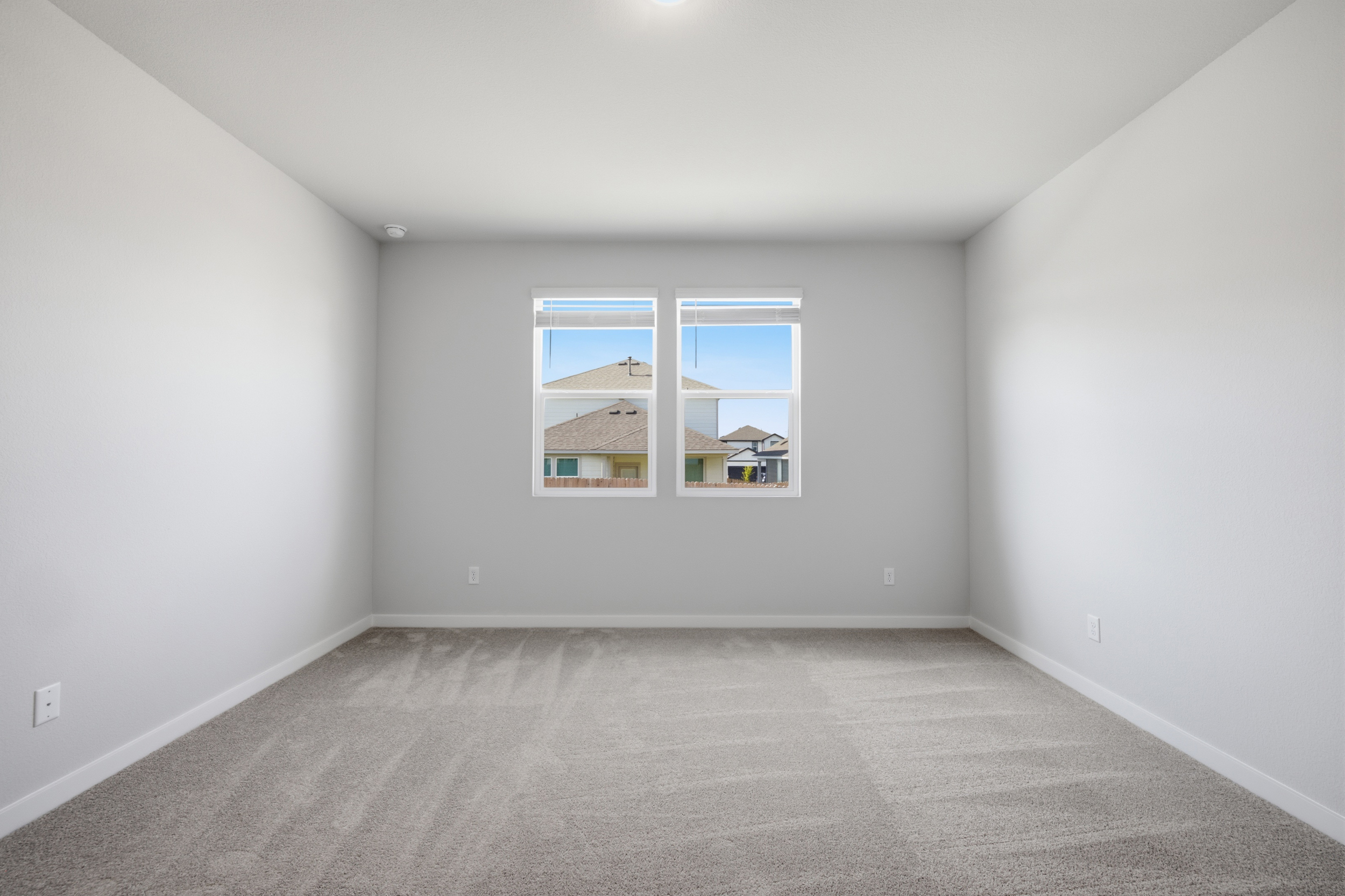 A room with a window and a carpet.
