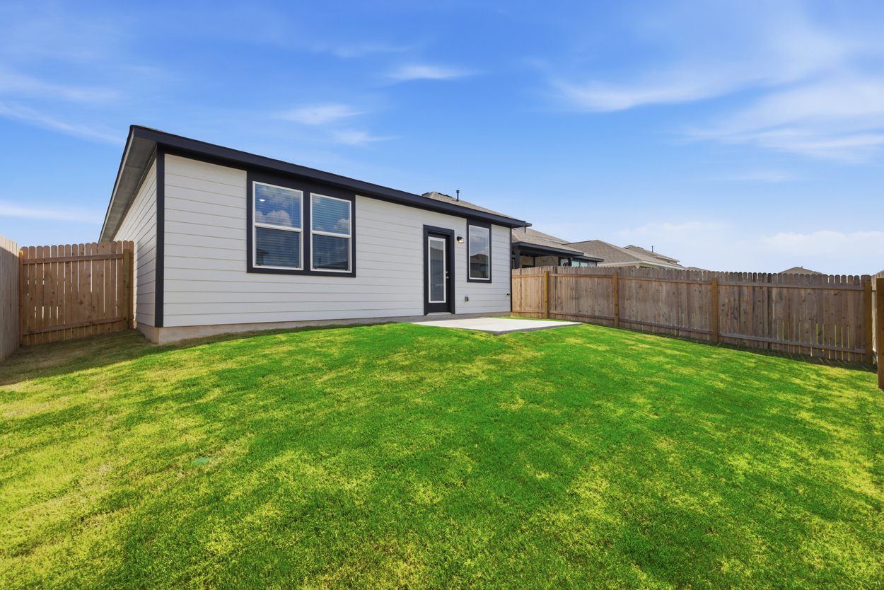 A house with a fence and grass.