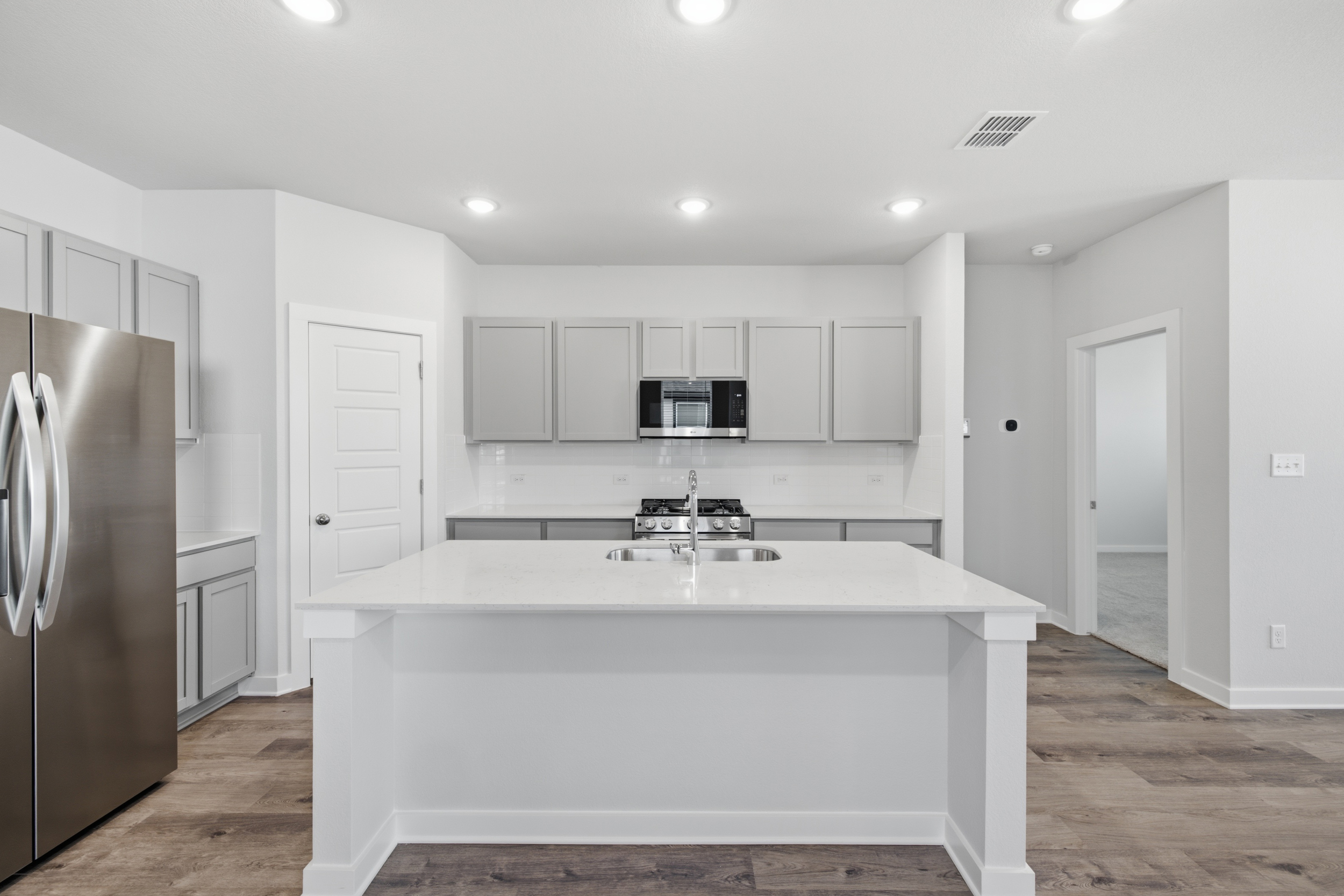 A kitchen with white cabinets.