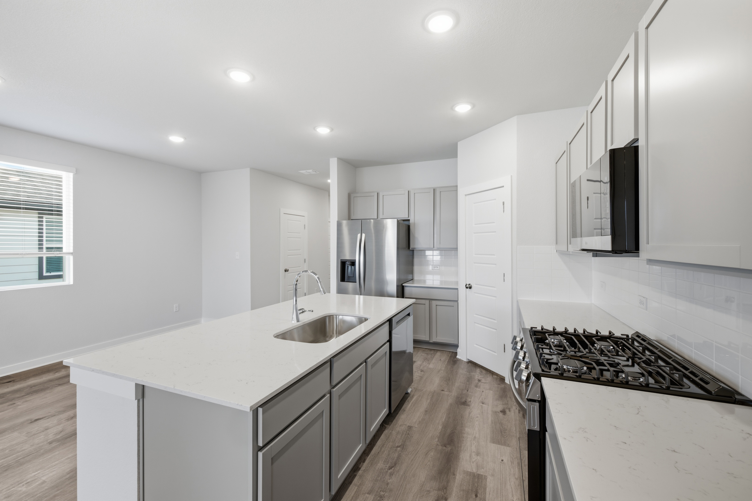 A kitchen with white cabinets.