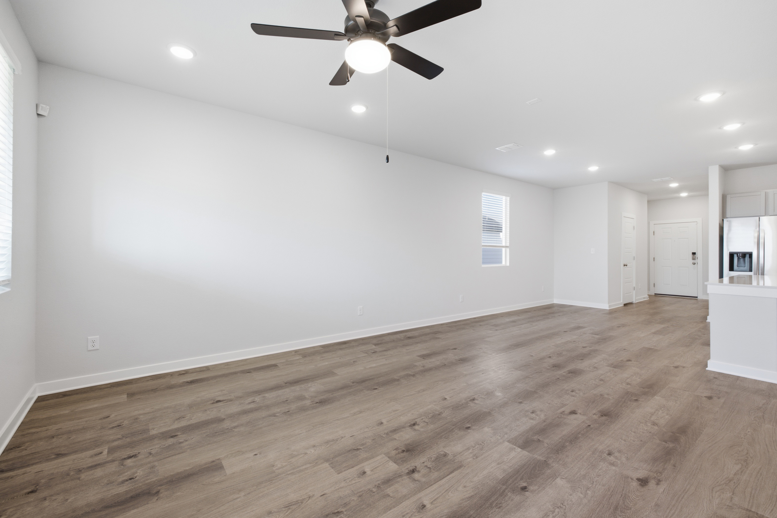 A room with a wood floor and a ceiling fan.