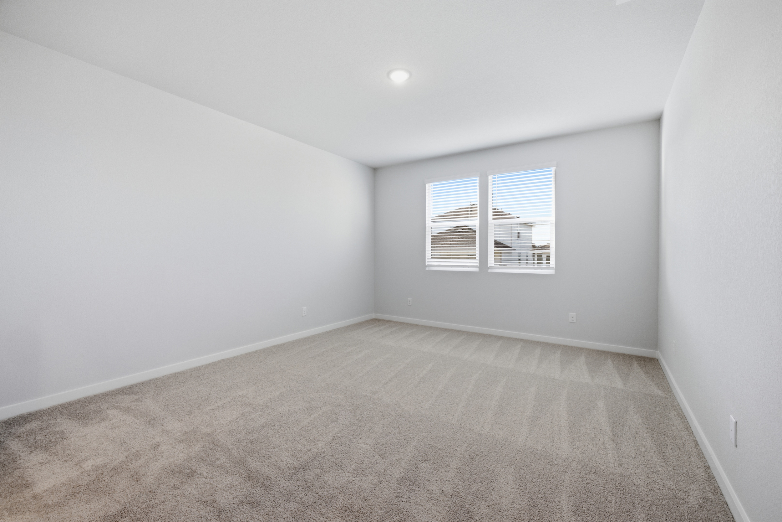 A room with a window and a carpet.