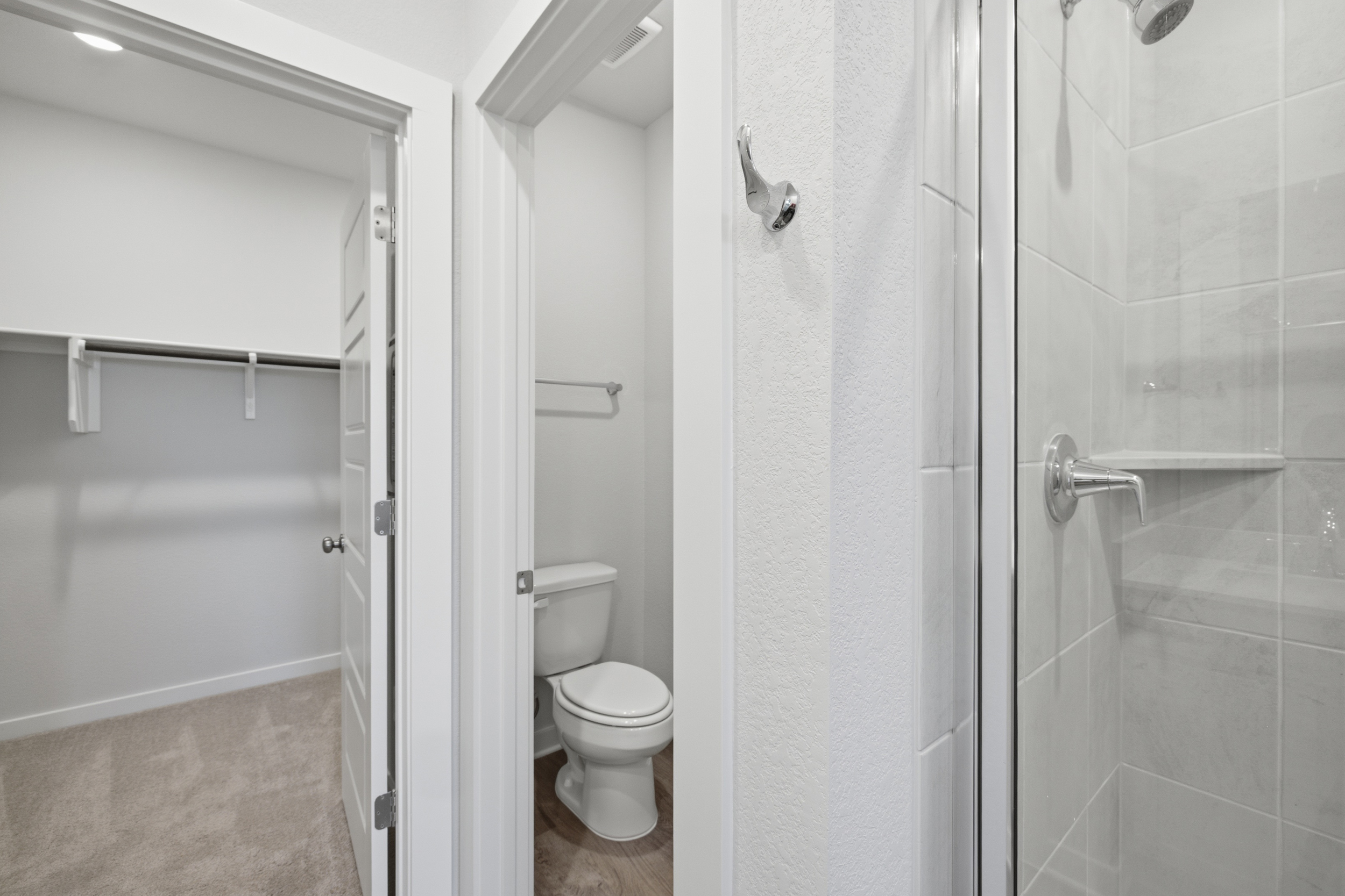 A bathroom with a shower unit and toilet.