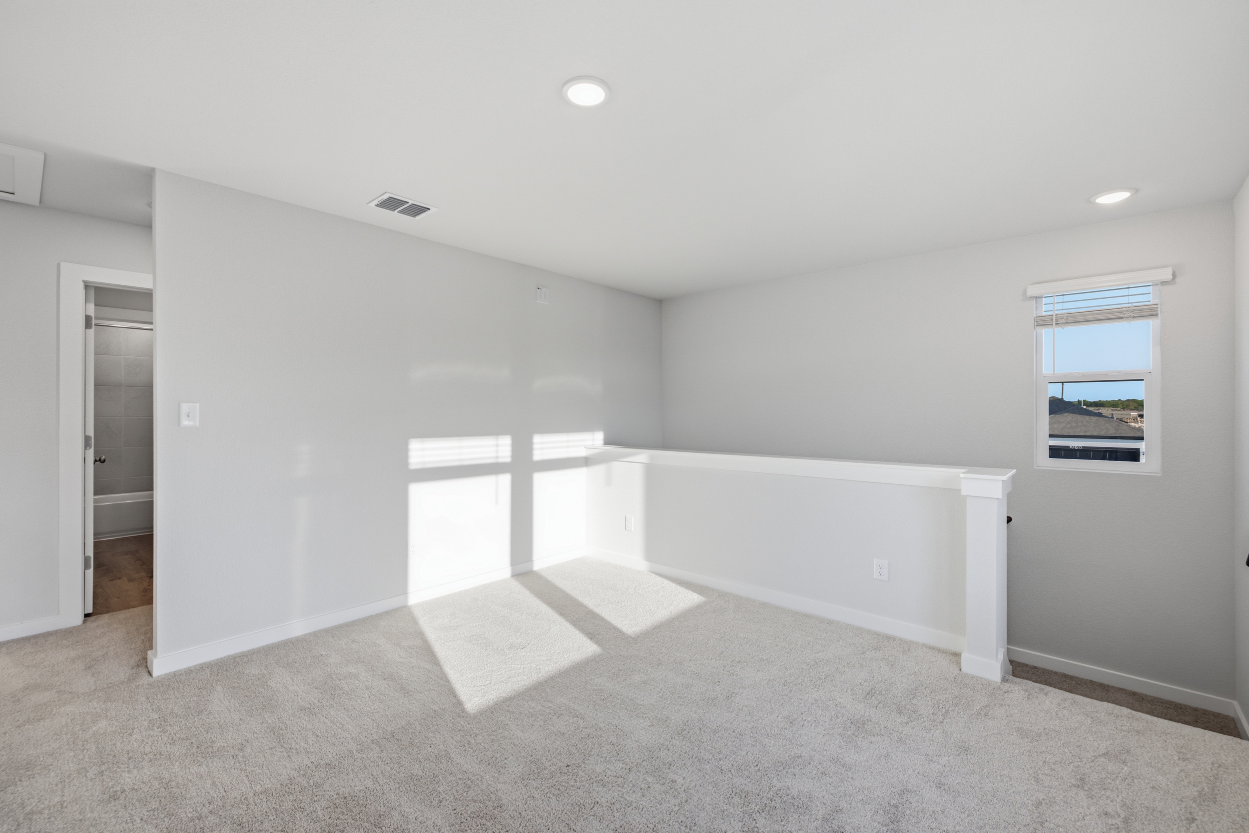 A room with a white wall and a window.