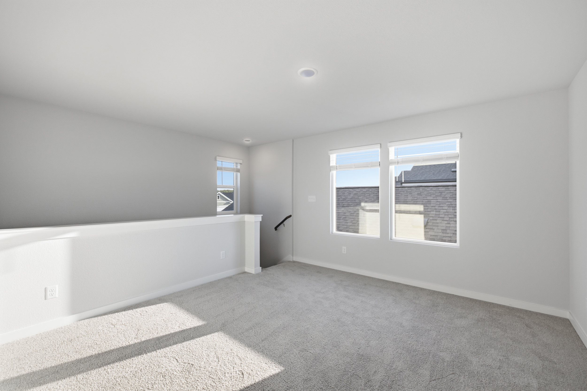 A room with a white wall and windows.