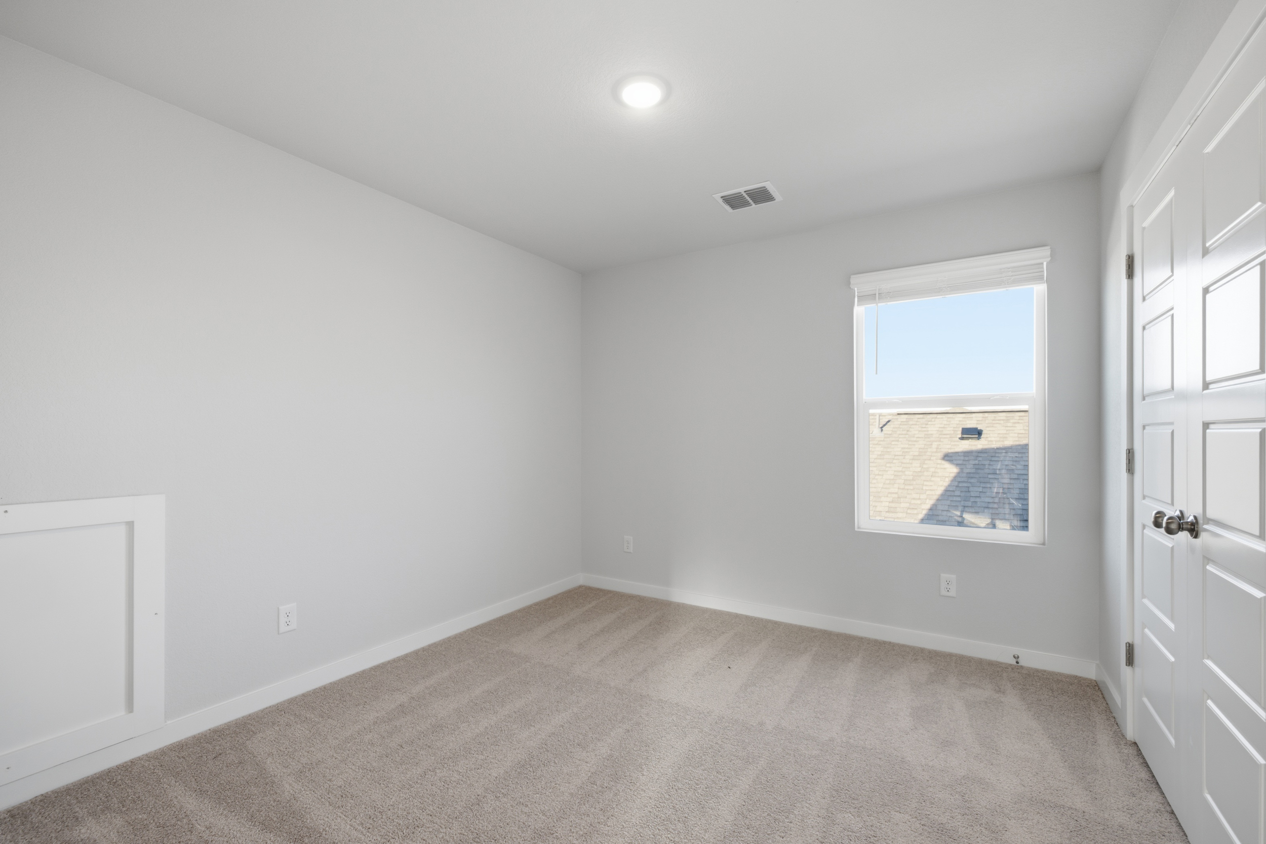 A room with white walls and a window.