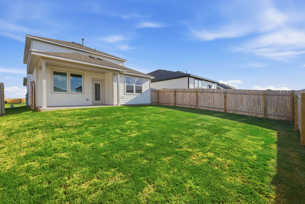 A house with a fence and grass.