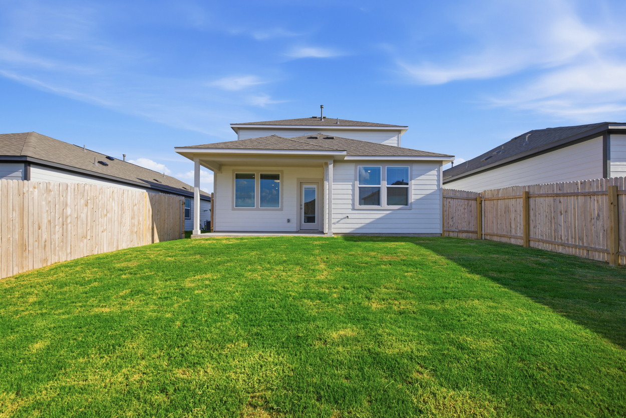 A house with a fence and grass.