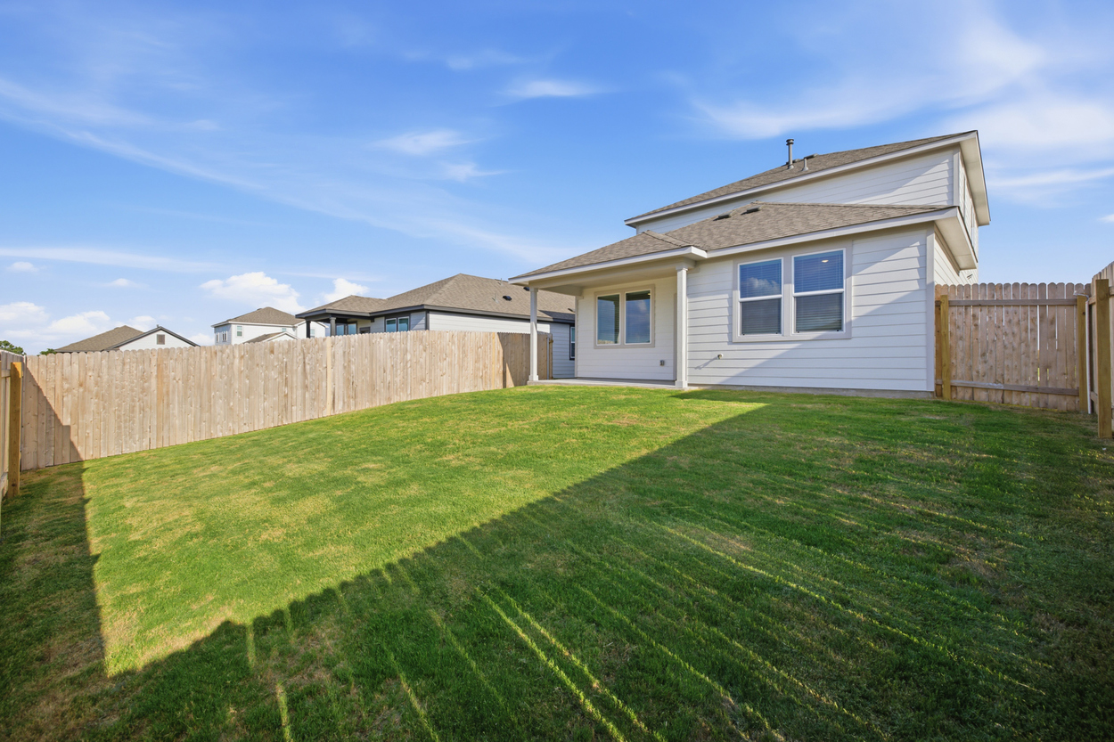 A house with a fence and grass.