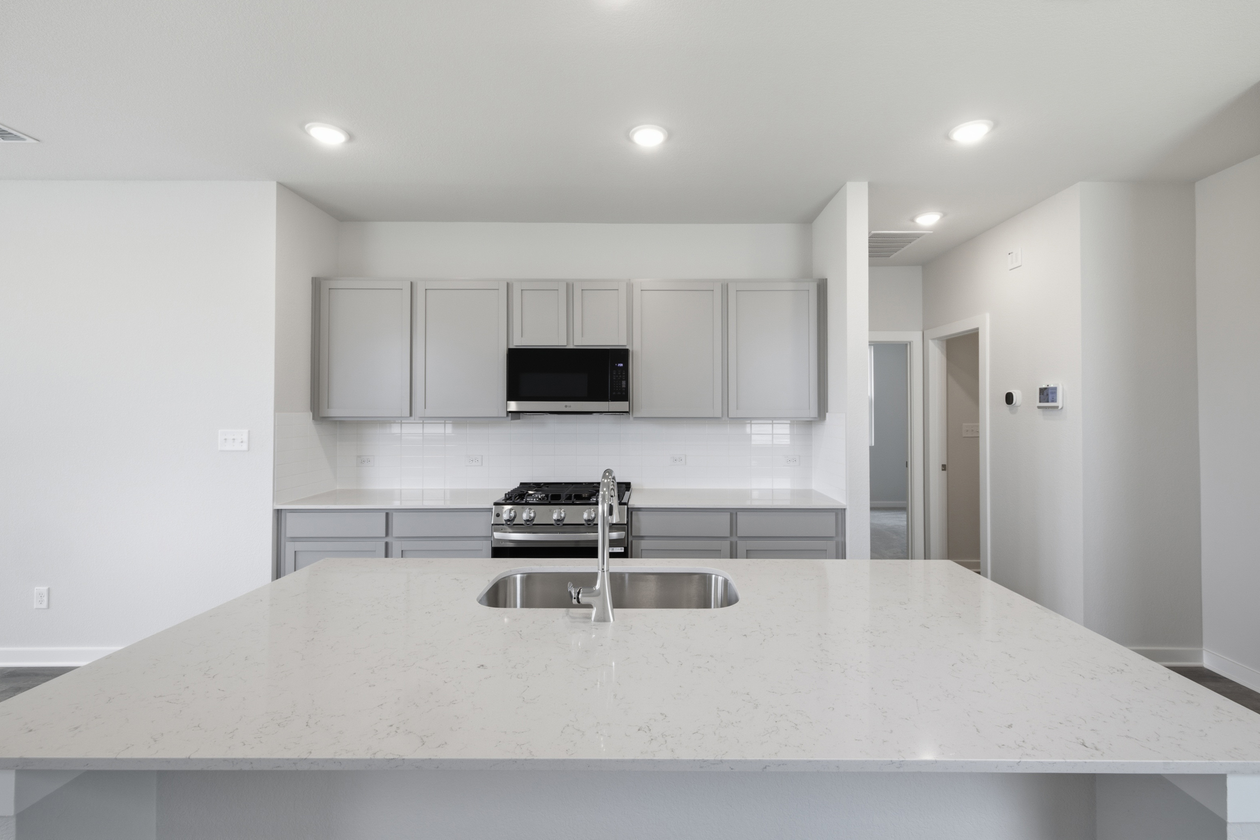 A kitchen with white cabinets.