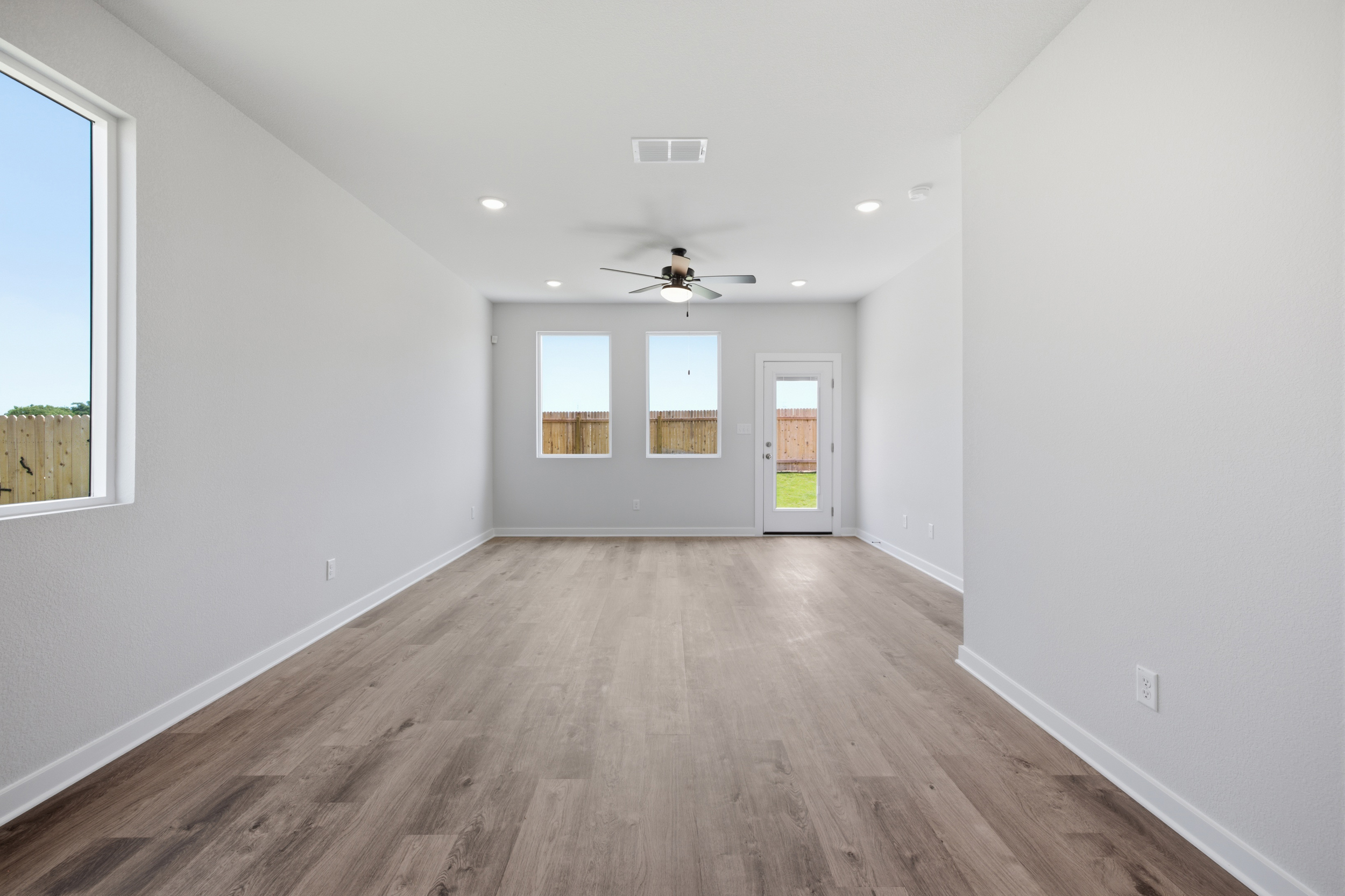 A room with a wood floor and a ceiling fan.