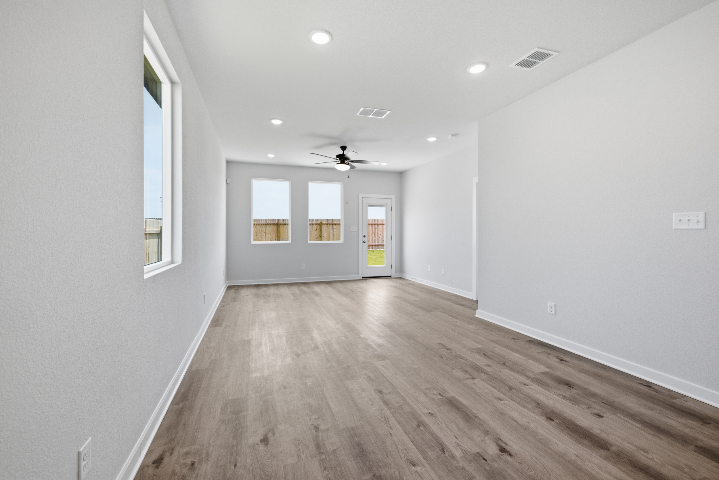 A room with white walls and wood floors.
