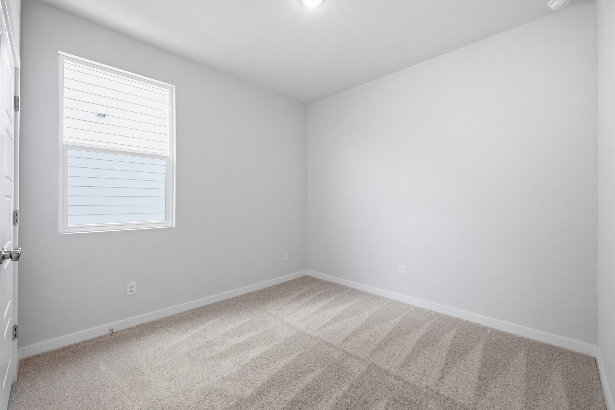A room with a carpet and a window.