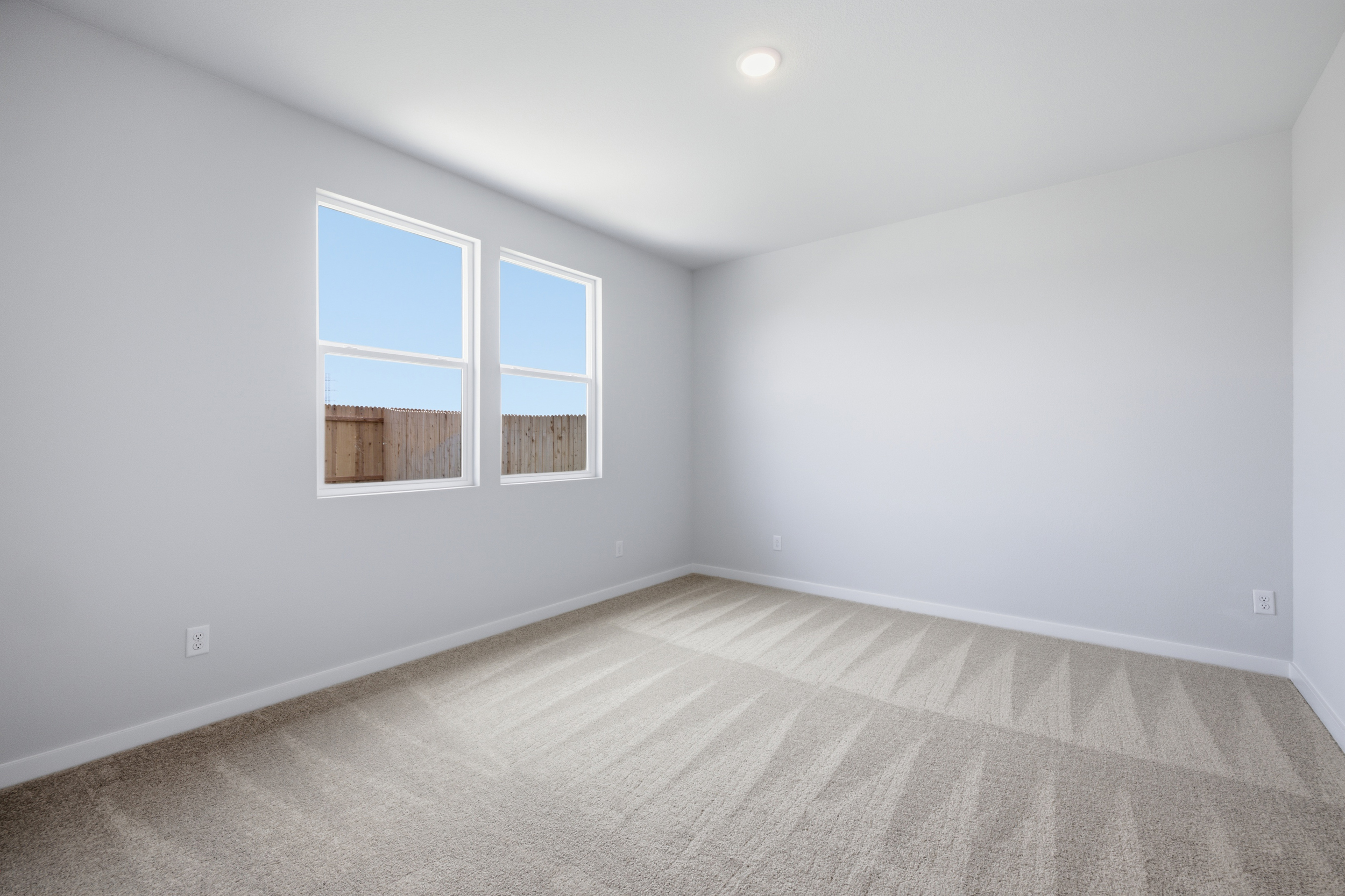A room with a window and a carpet.