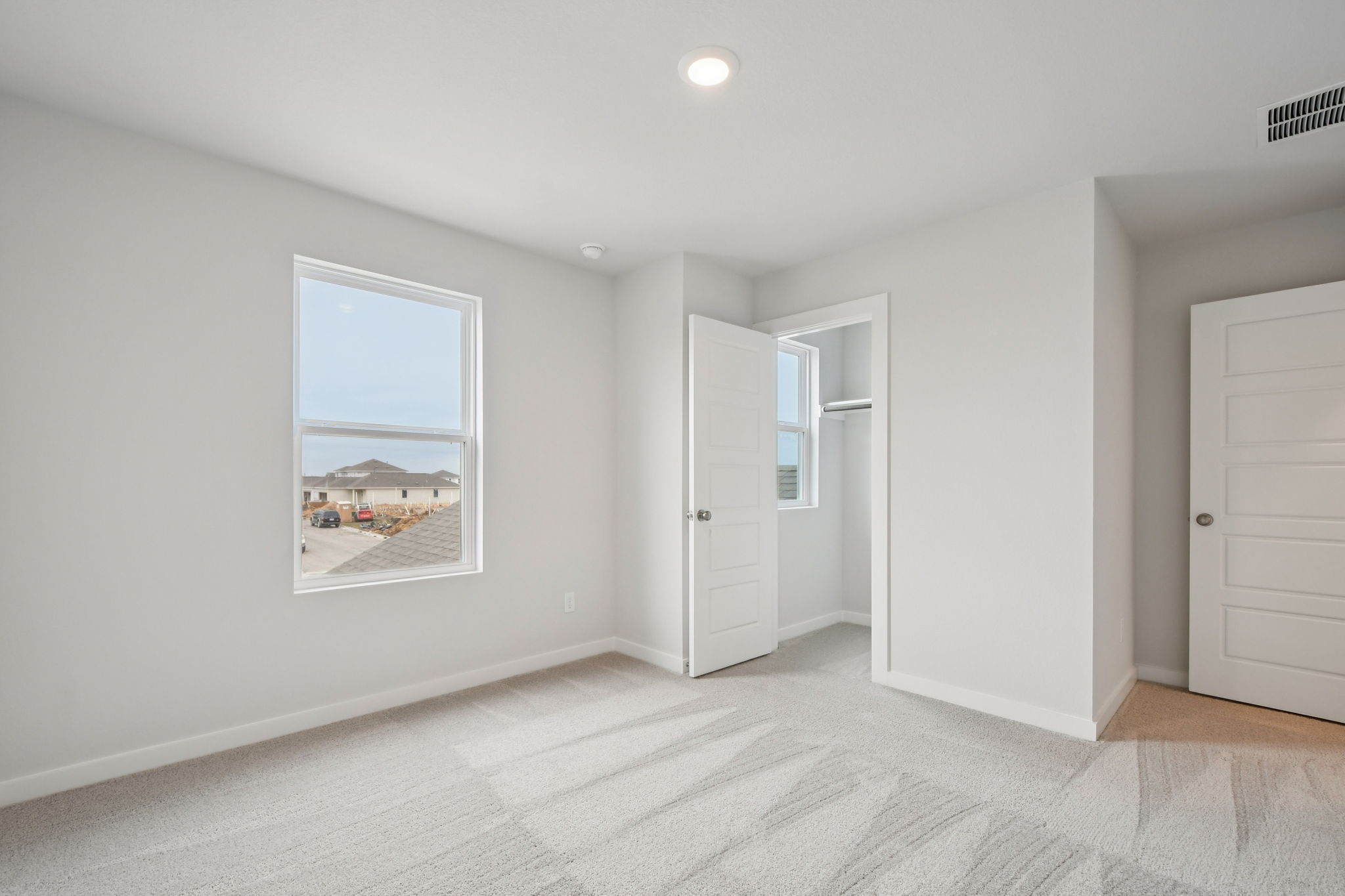 A room with white walls and a window.