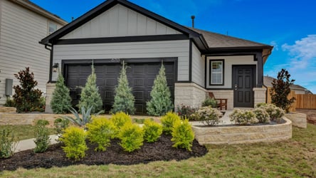A house with a garden in the front yard.