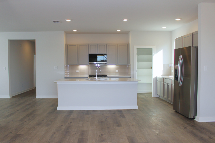 A kitchen with white cabinets.