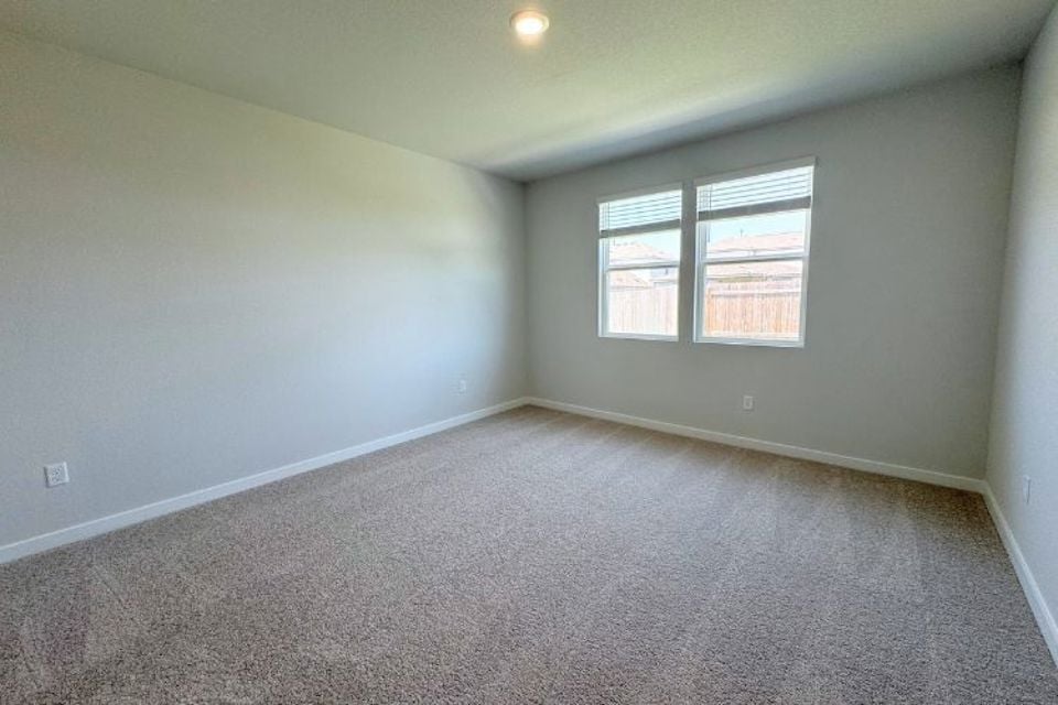 A room with a carpet and a window.