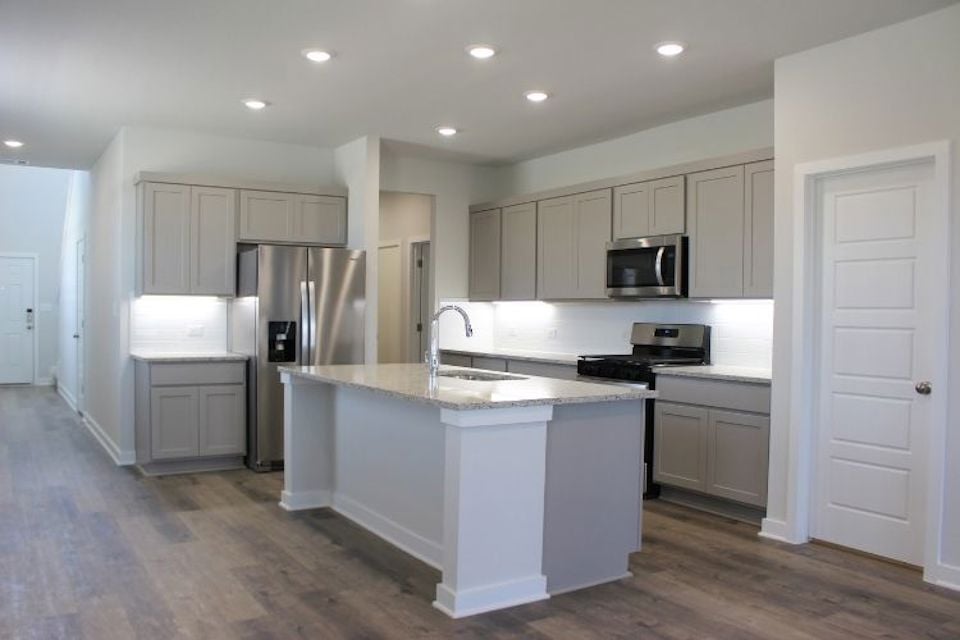 A kitchen with white cabinets.