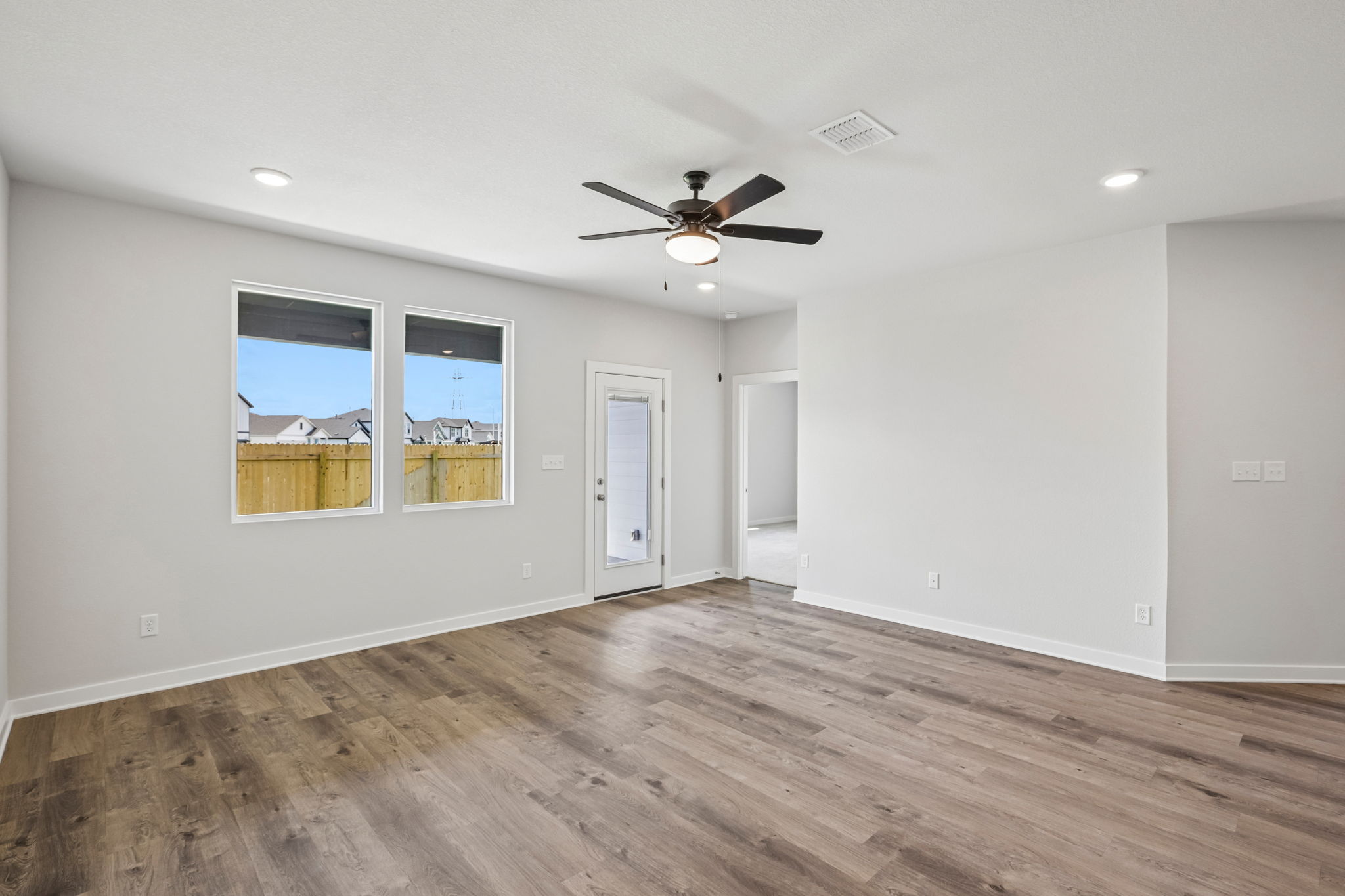 A room with a wood floor and a ceiling fan.