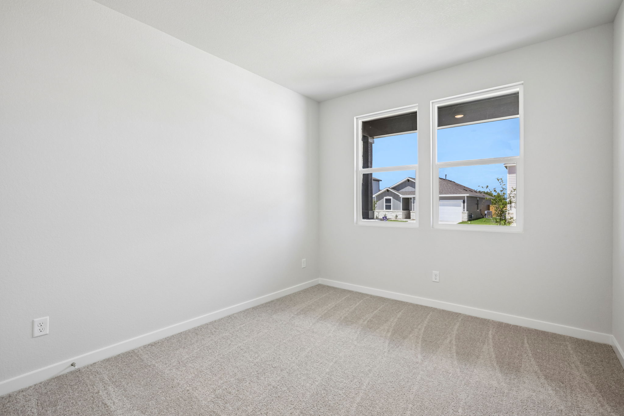 A room with a window and a carpet.