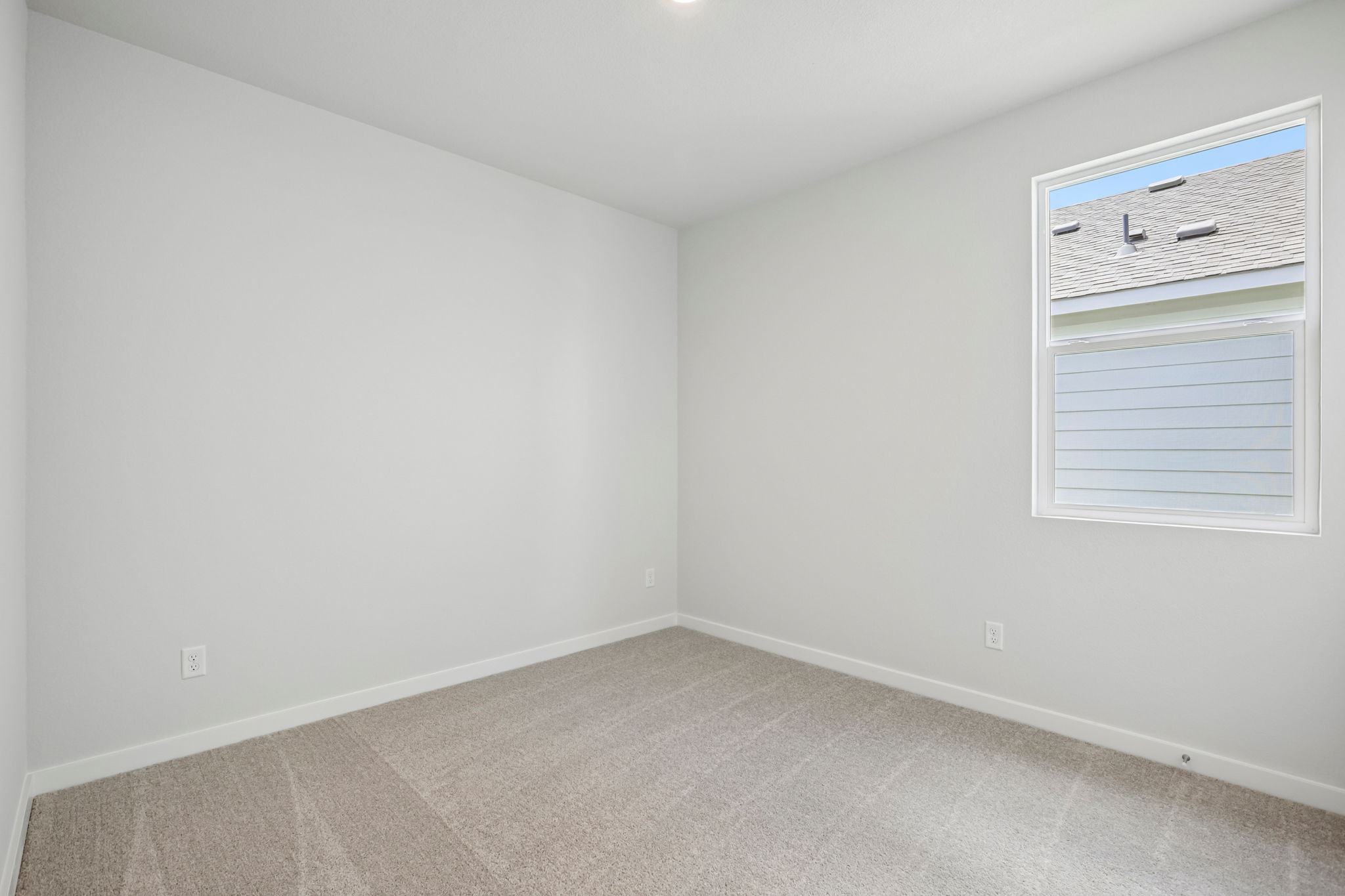 A room with a window and a rug.
