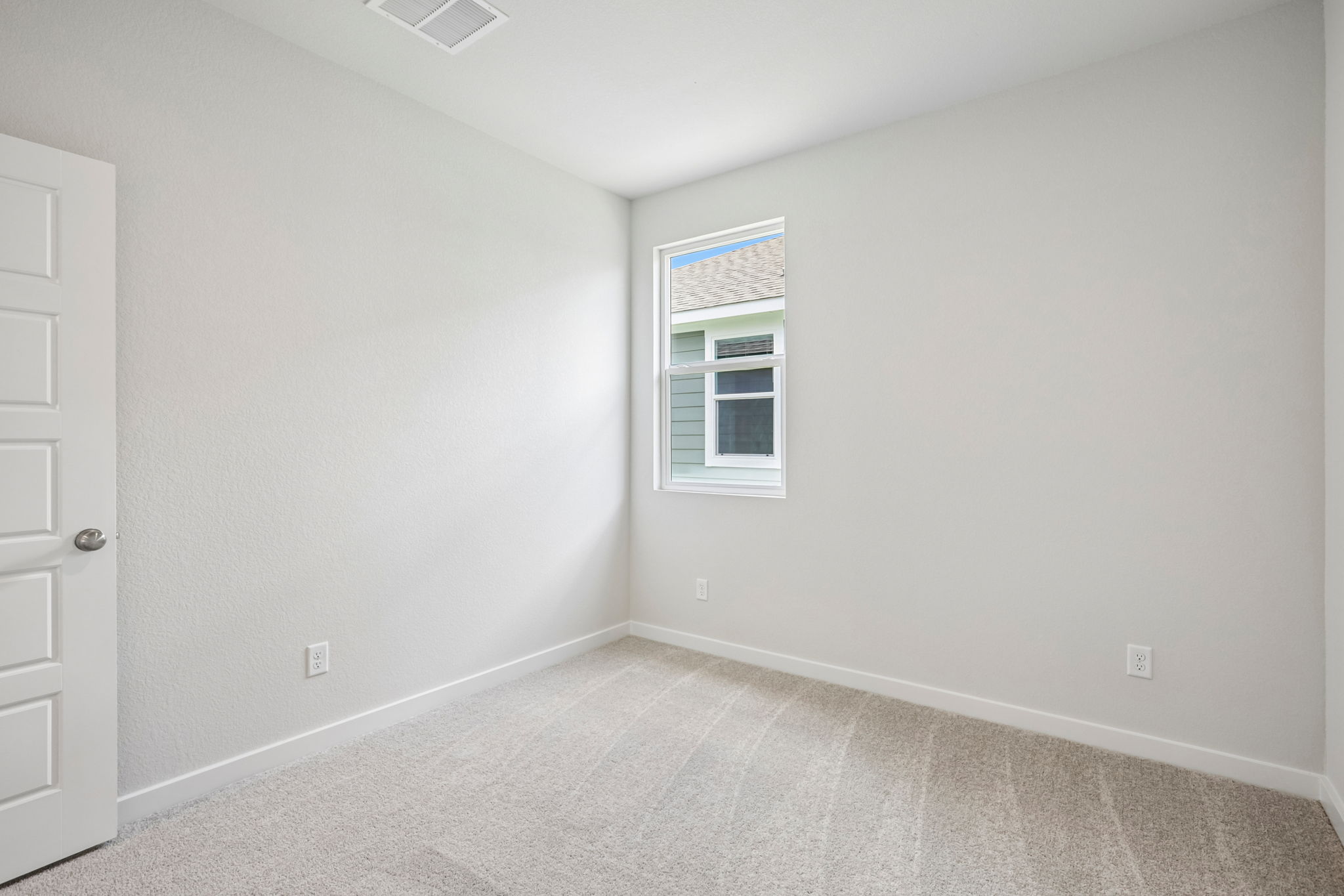 A room with a window and a carpet.
