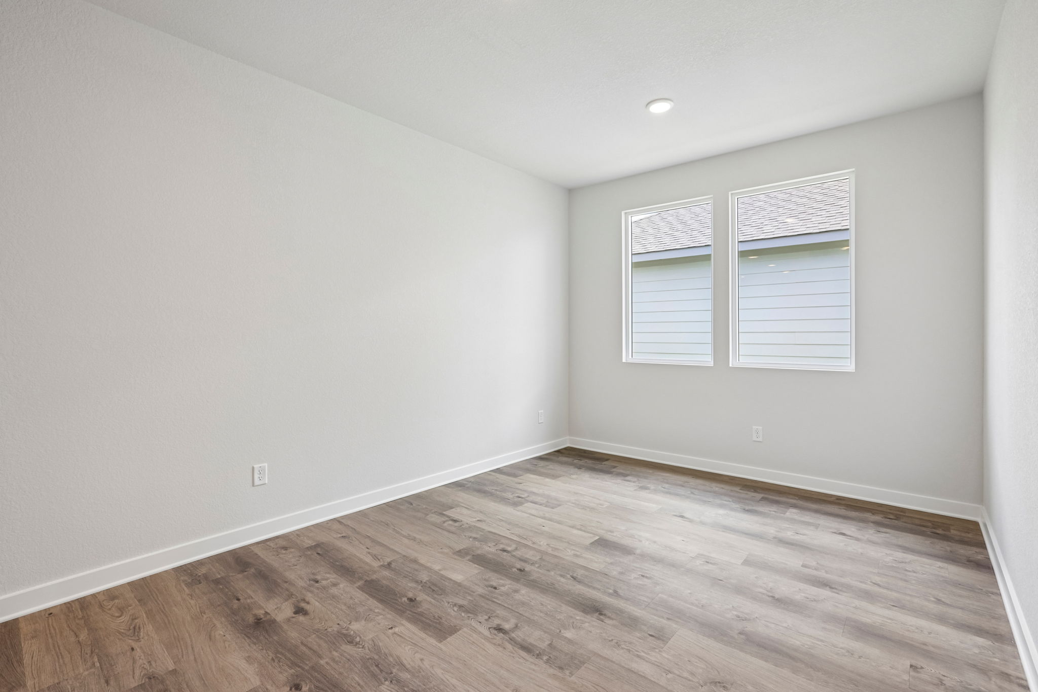 A room with a wood floor and a window.
