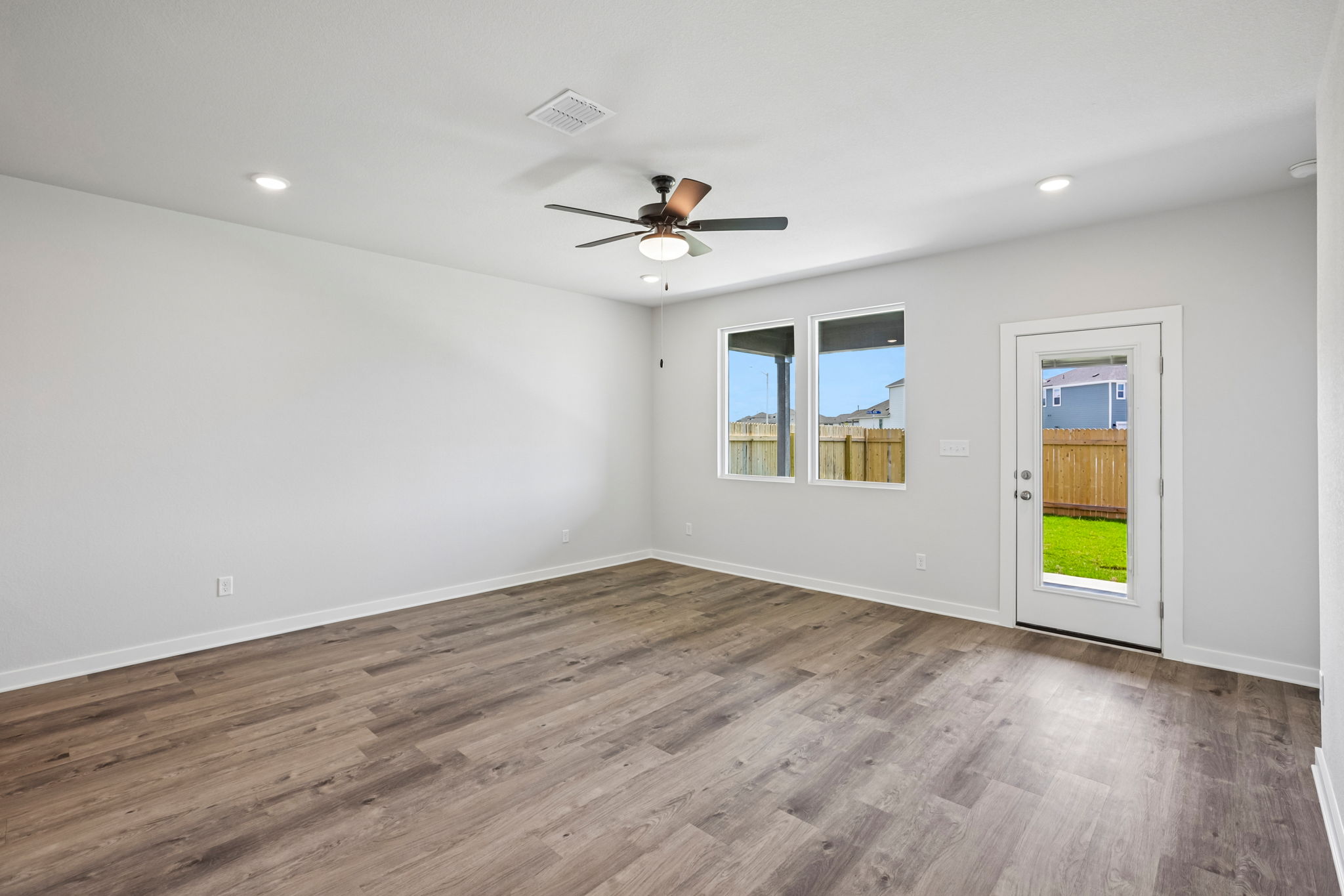 A room with a wood floor and a ceiling fan.