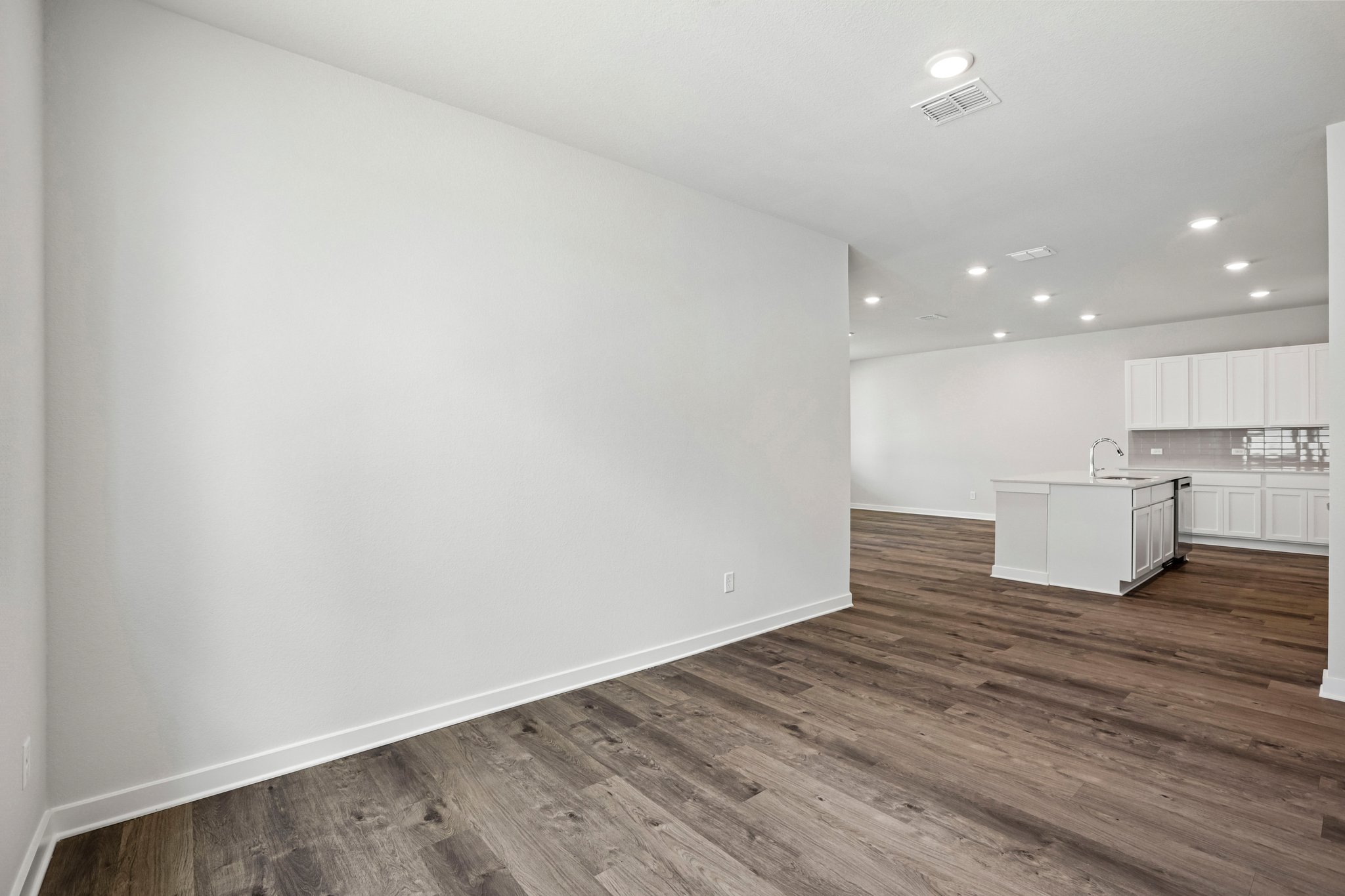 A room with a wood floor and white walls.