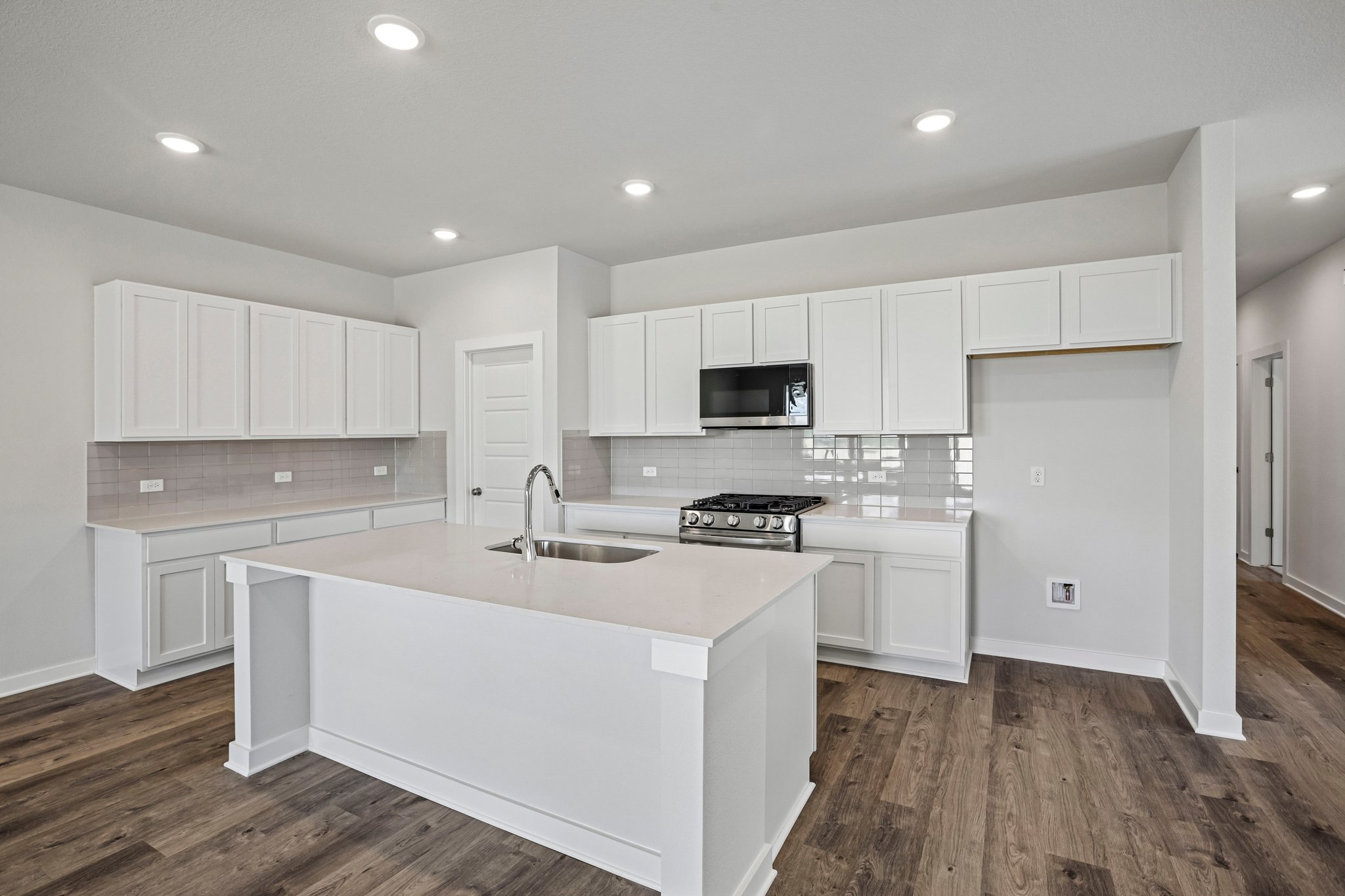 A kitchen with white cabinets.