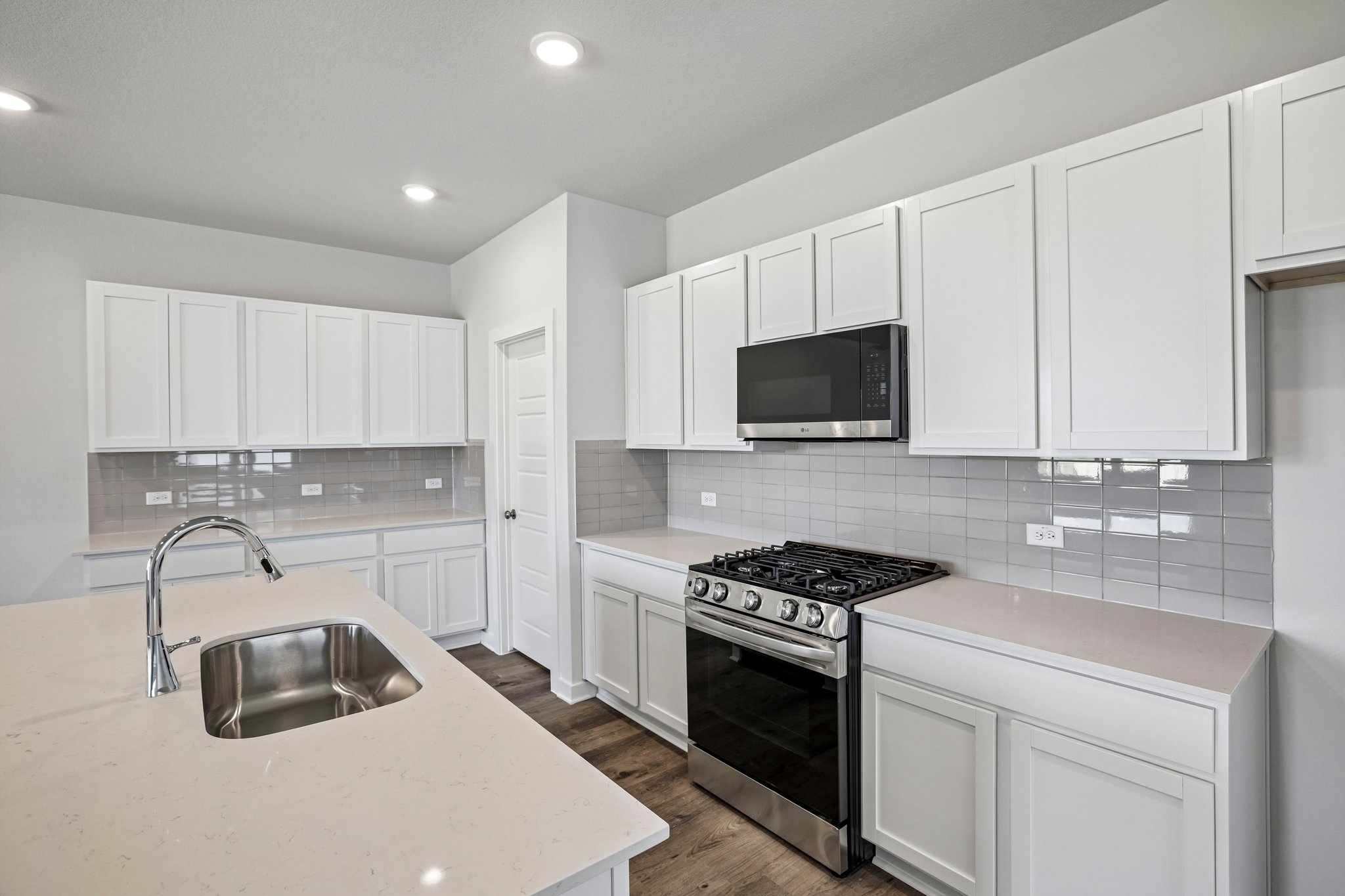 A kitchen with white cabinets.