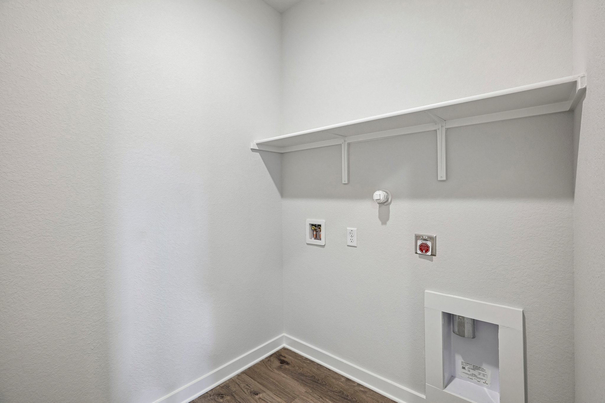 A white wall with a white shelf.