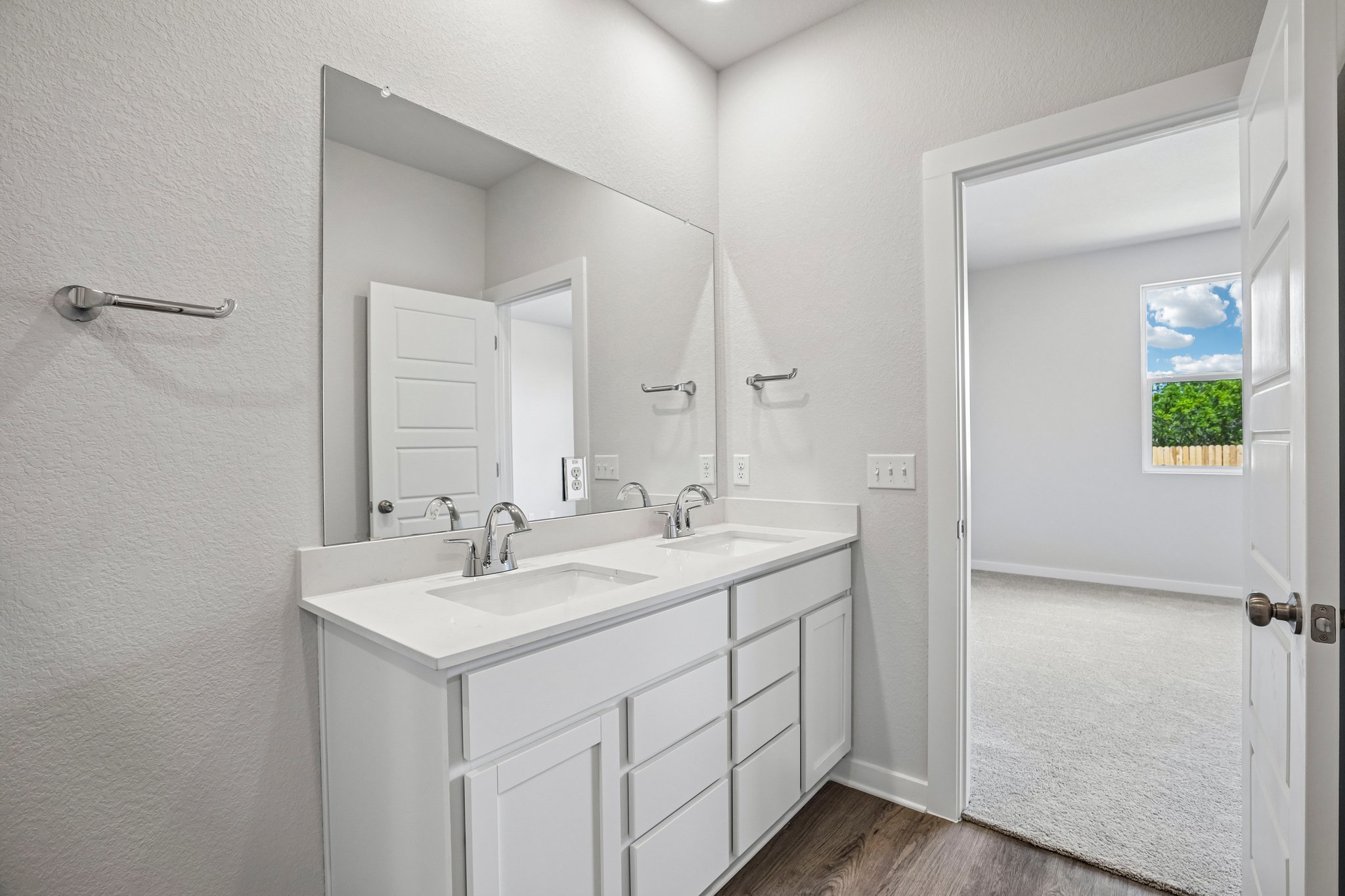 A bathroom with white cabinets.