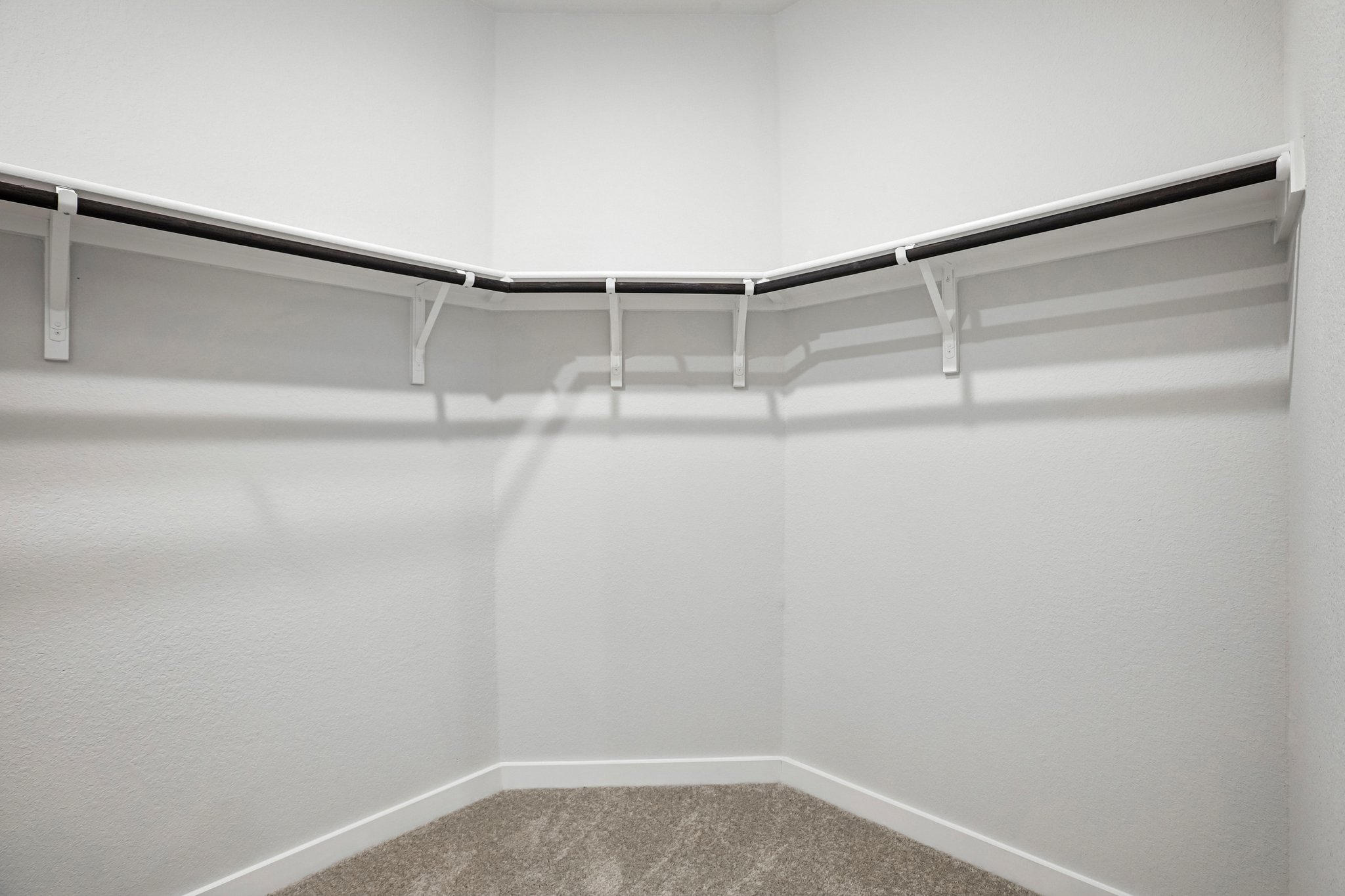 A white wall with a metal railing.
