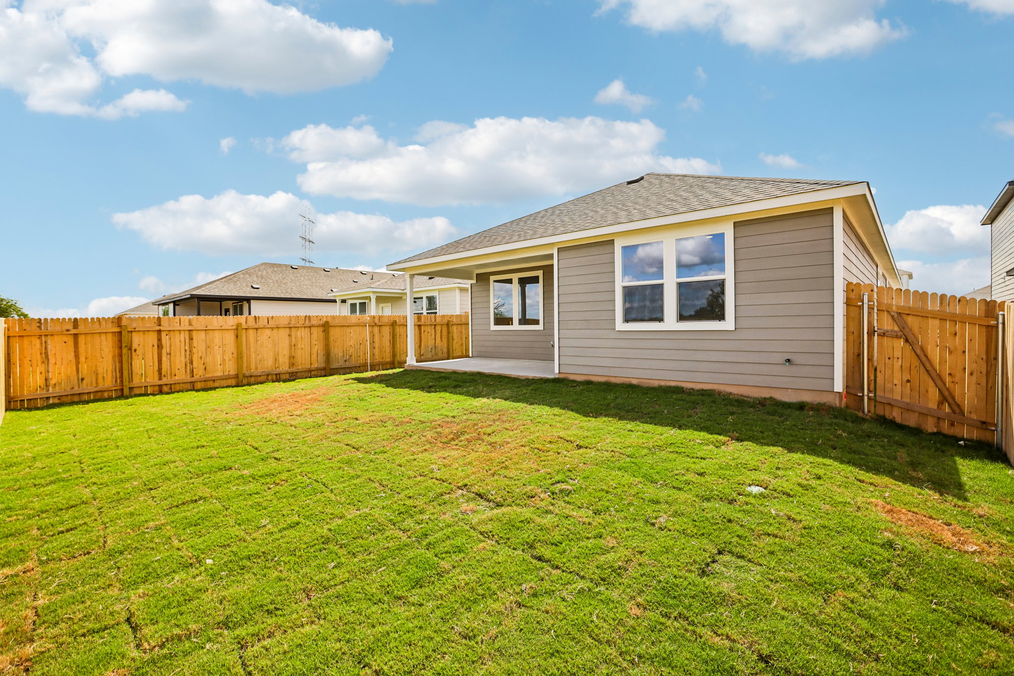 A house with a fence and grass.