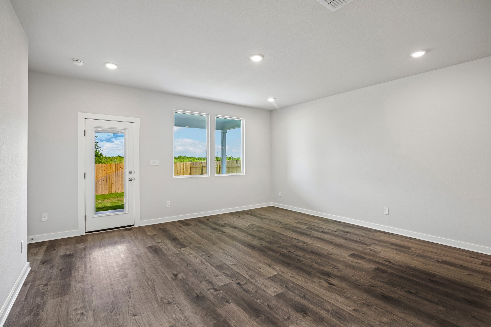 A room with a wood floor and a wood floor with a window.