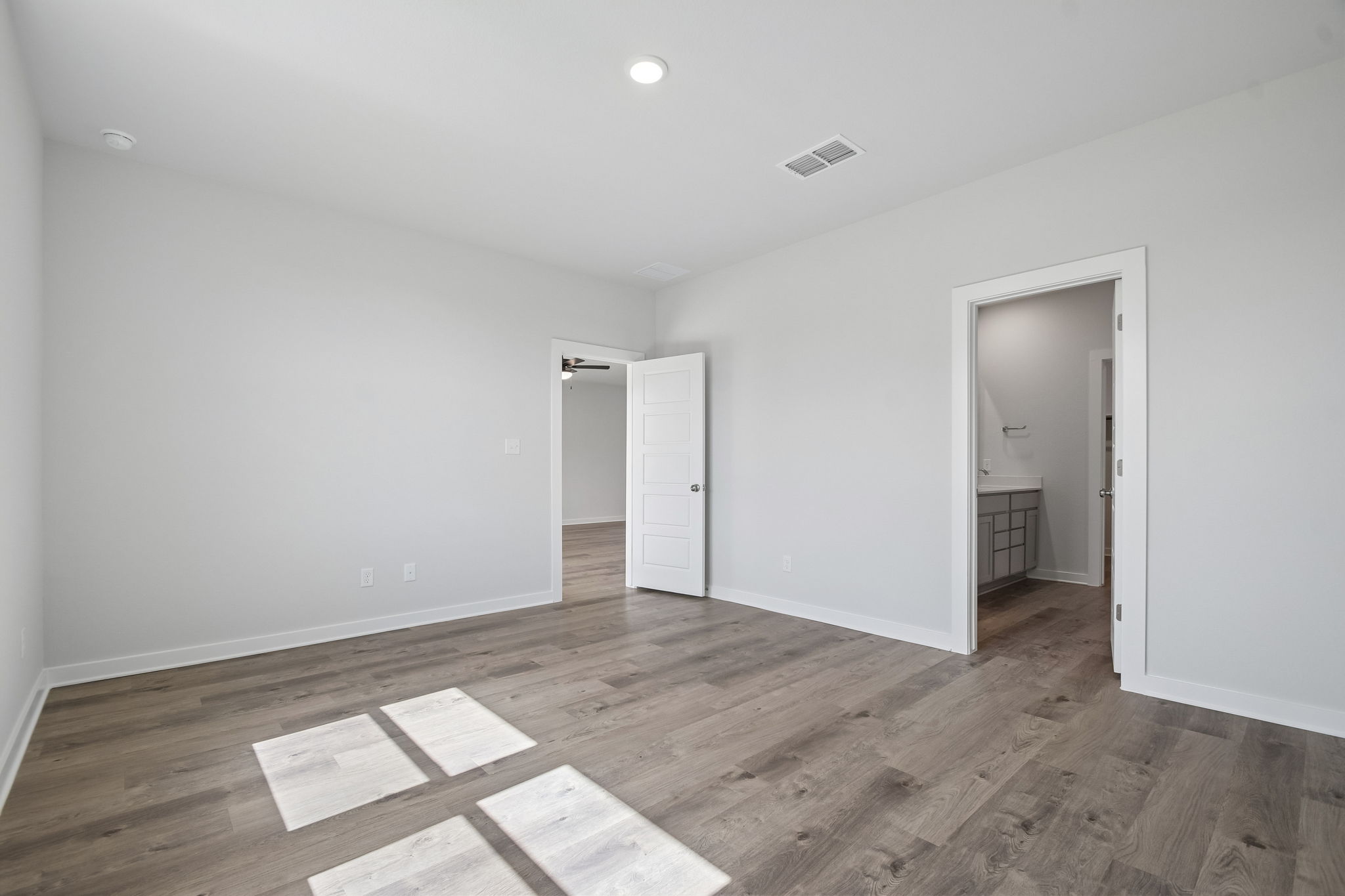 A room with a wood floor and white walls.