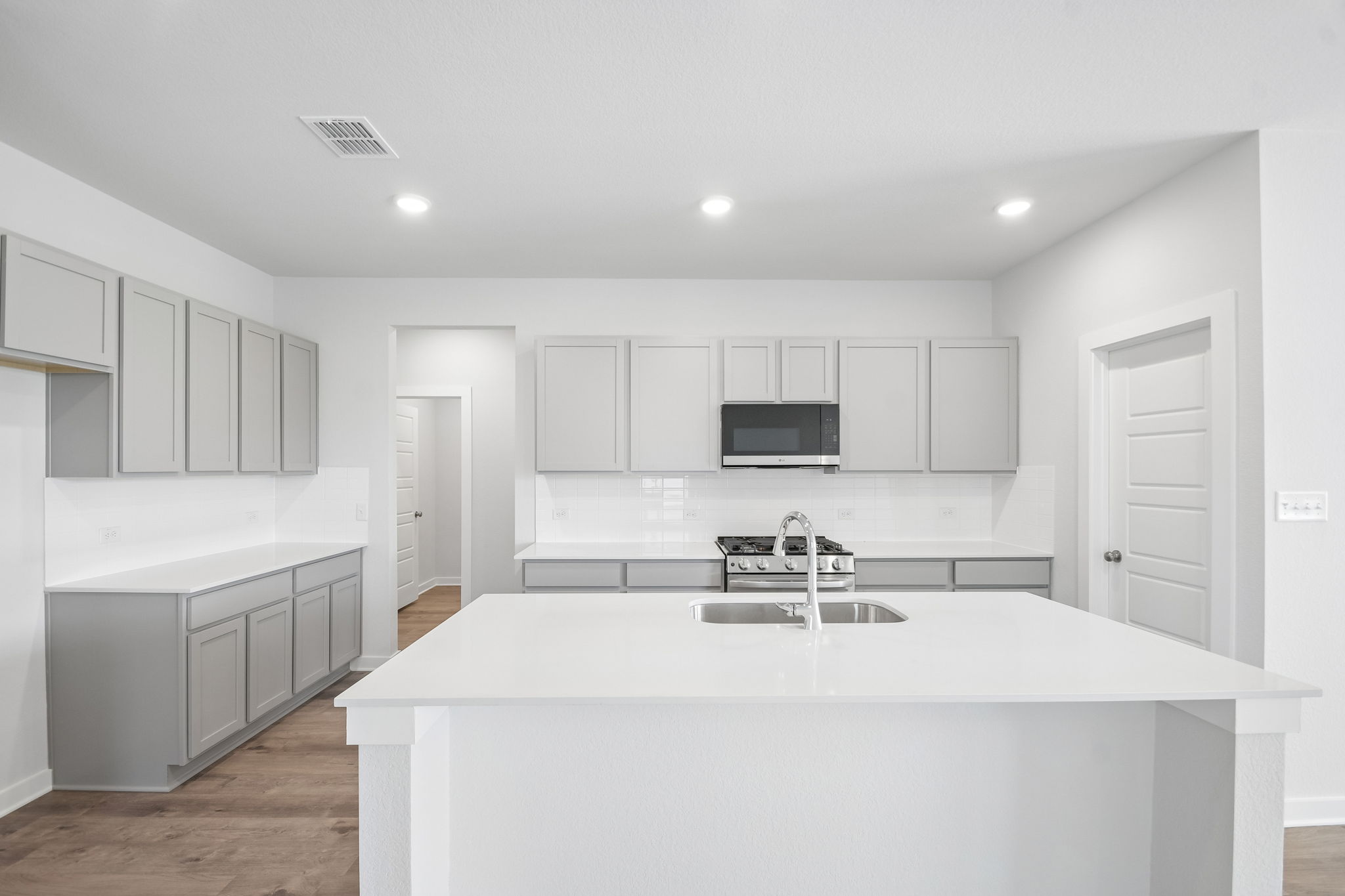 A kitchen with white cabinets.
