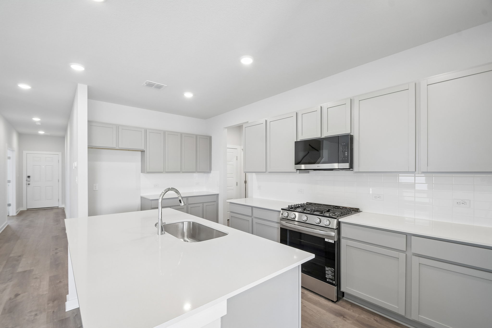 A kitchen with white cabinets.