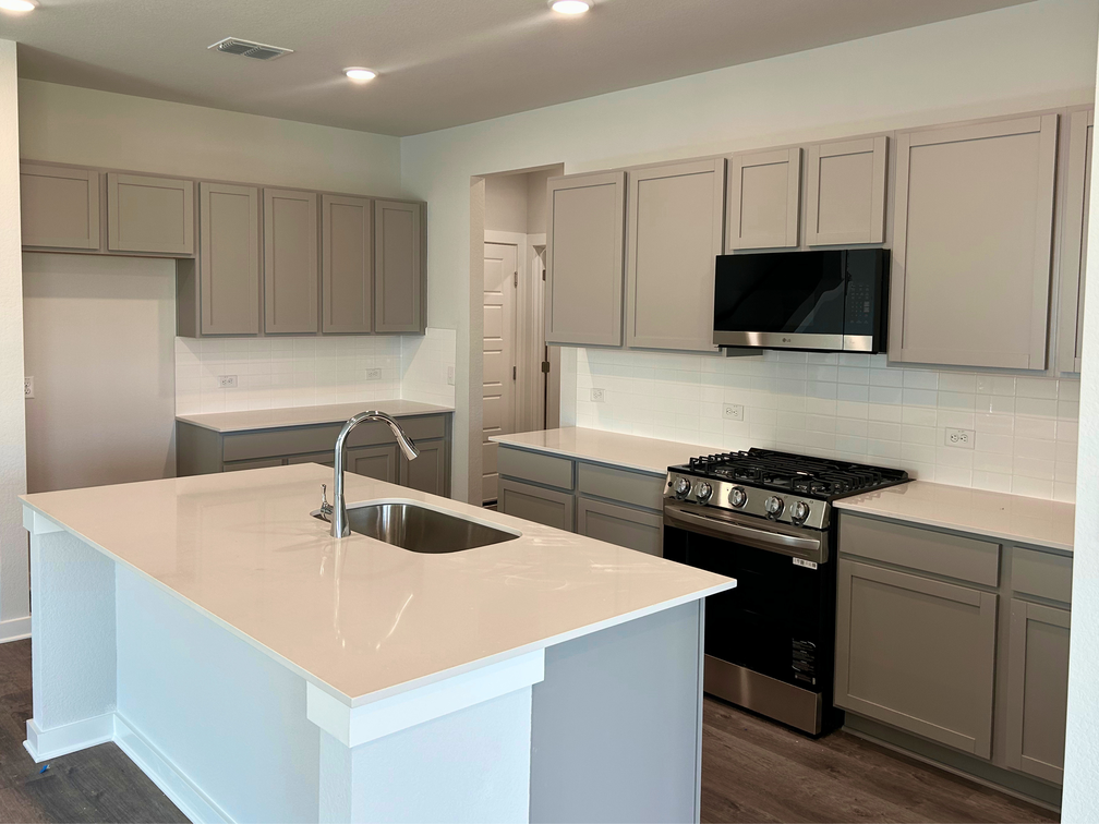 A kitchen with white cabinets.